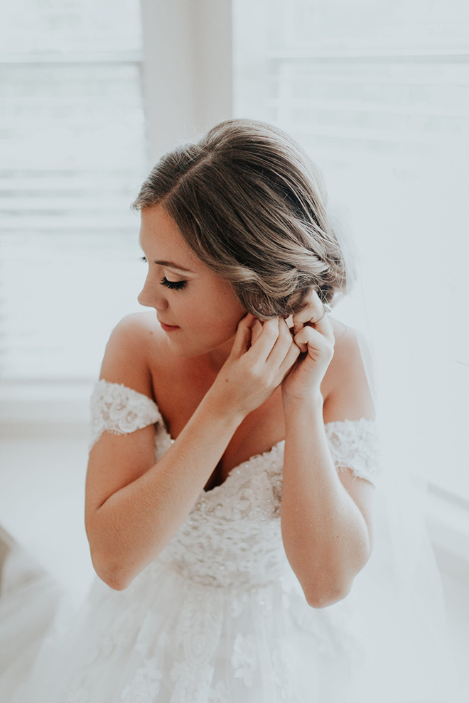 real wedding houston wedding the woodlands resort & conference center bride getting ready wedding day prep bridal jewelry white off the shoulder wedding dress braided updo