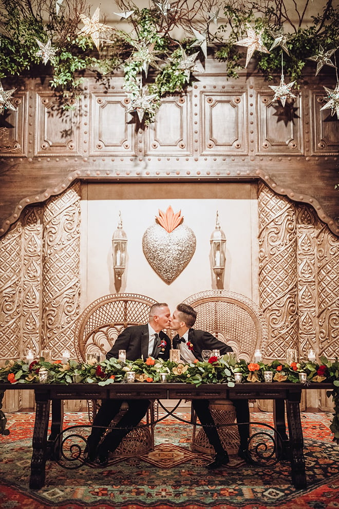 reception decor, couple's table, greenery, red, orange, yellow, flowers, metal, spanish-inspired wedding, same sex wedding, grooms, gay wedding, lgbt