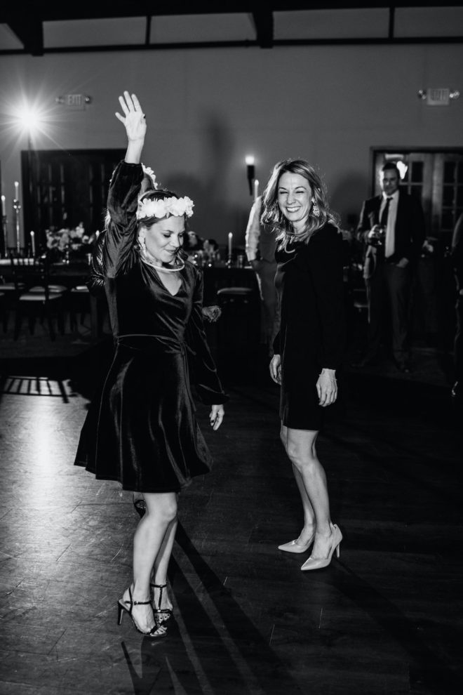 Black and white image of guests dancing at wedding reception. 