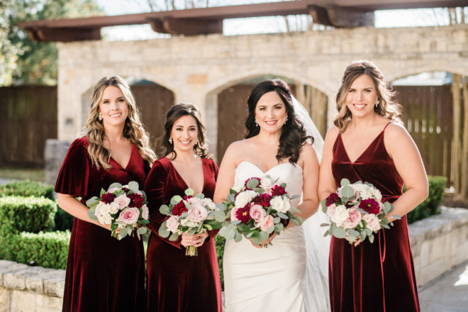 Bride and bridesmaids in wine dressed with wine and blush bouquets. 