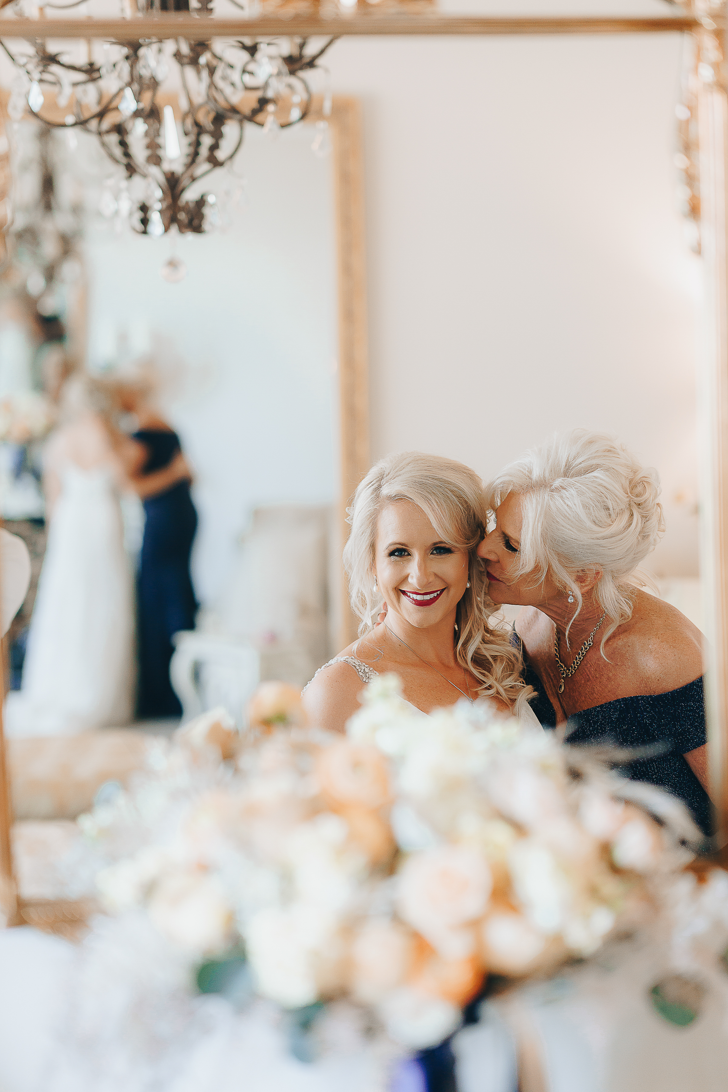 Mother of the Bride kissing the bride on the cheek.