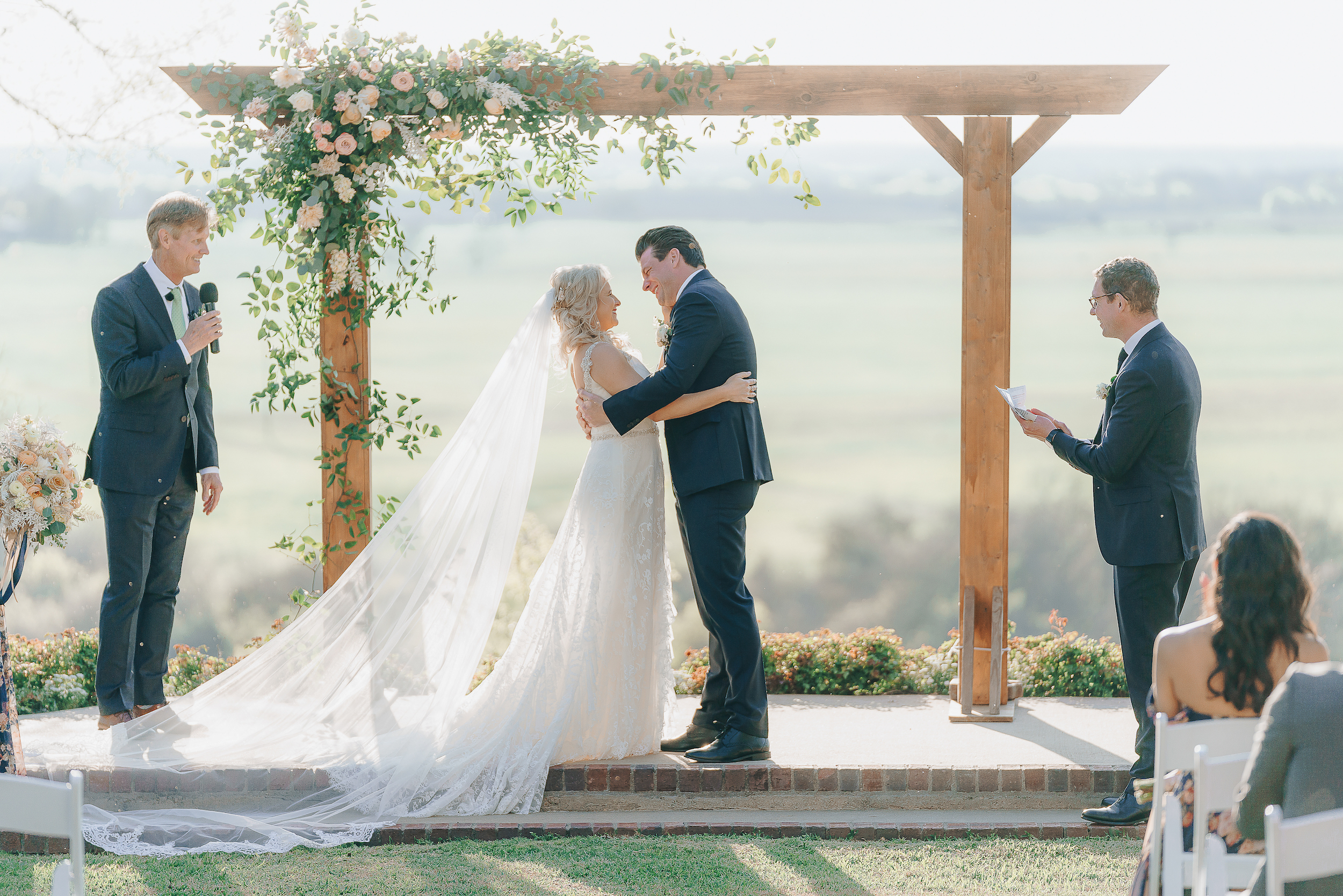 Bride and groom embracing at the altar with a view of the Hill Country.