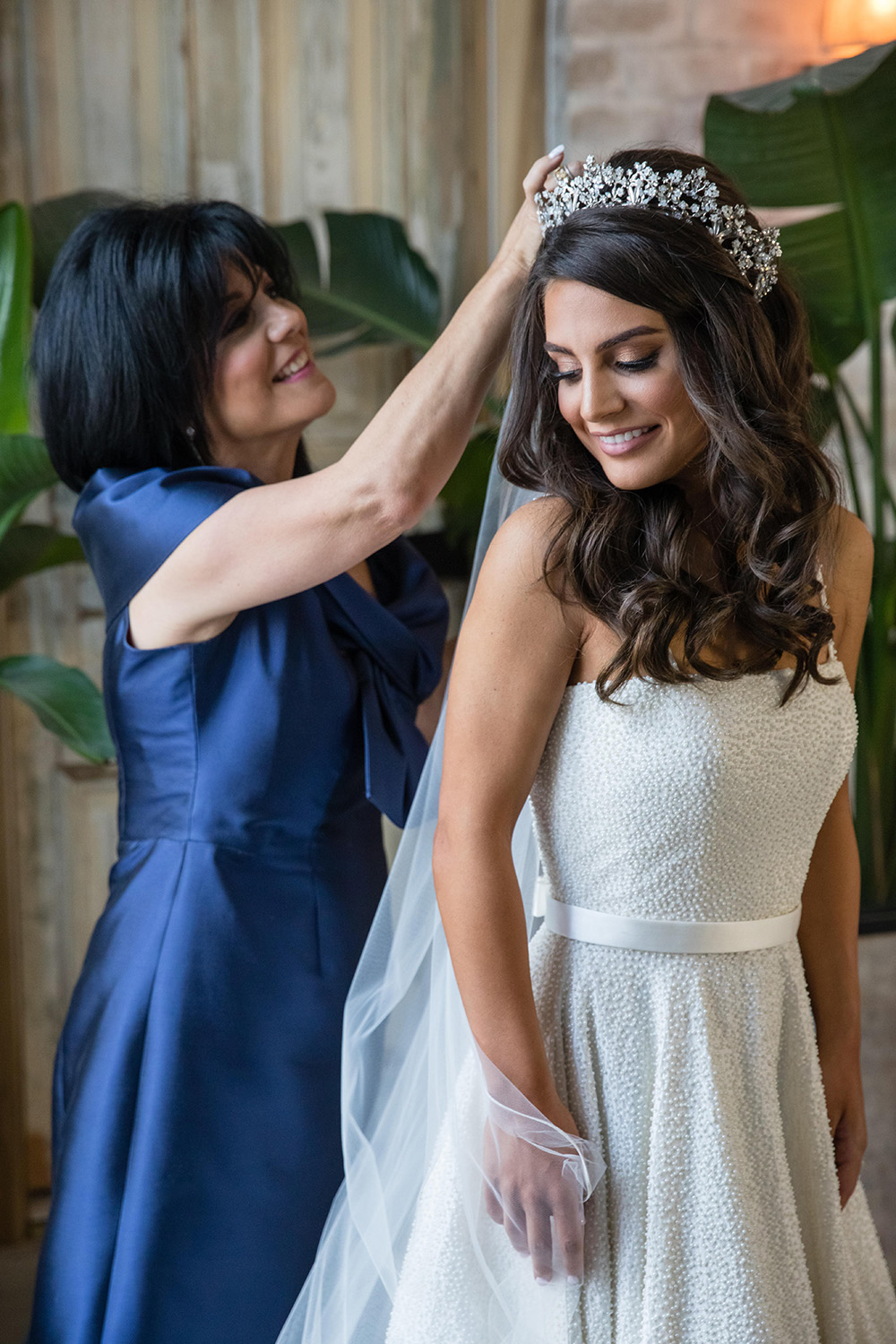 Mother of the bride adjusting her daughters veil. 