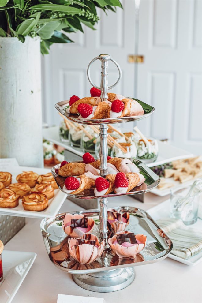 A decadent three-tier dessert tower with raspberry canoilis and dragonfruit mousse with Chantilly in chocolate cups.