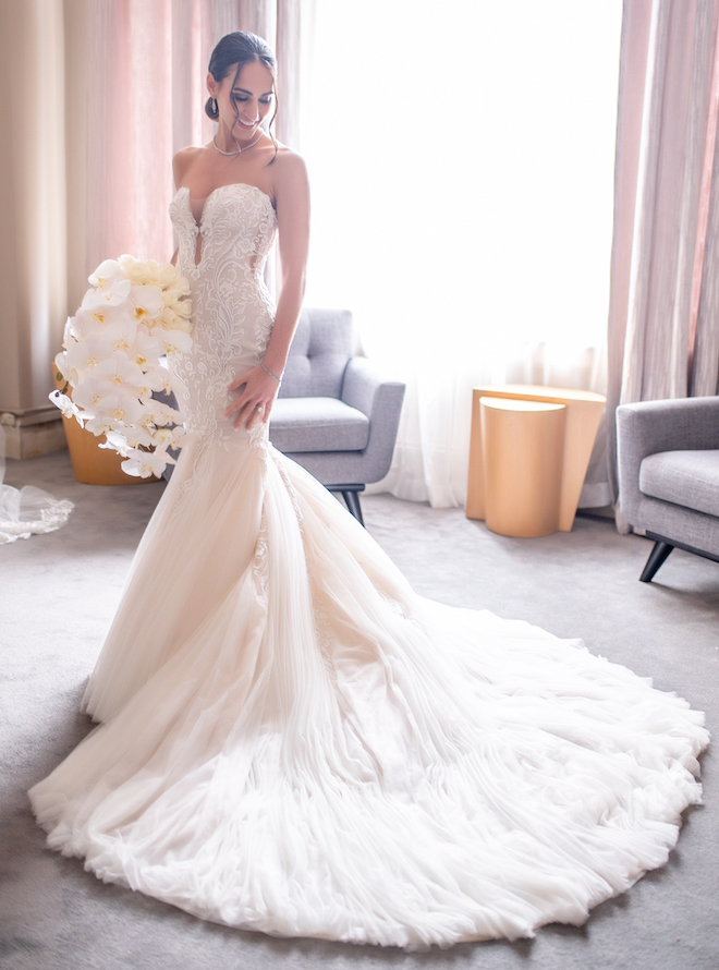 Bride in a fitted white mermaid wedding dress with an extended train.