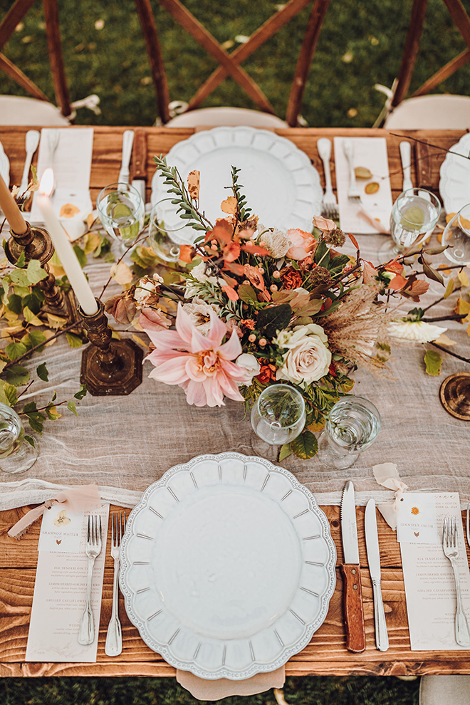 The wedding photographer captures the beautiful fall wedding reception table from above.