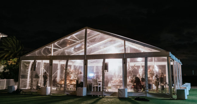 Outdoor clear tent at night during a wedding reception on a private property on Galveston Bay.