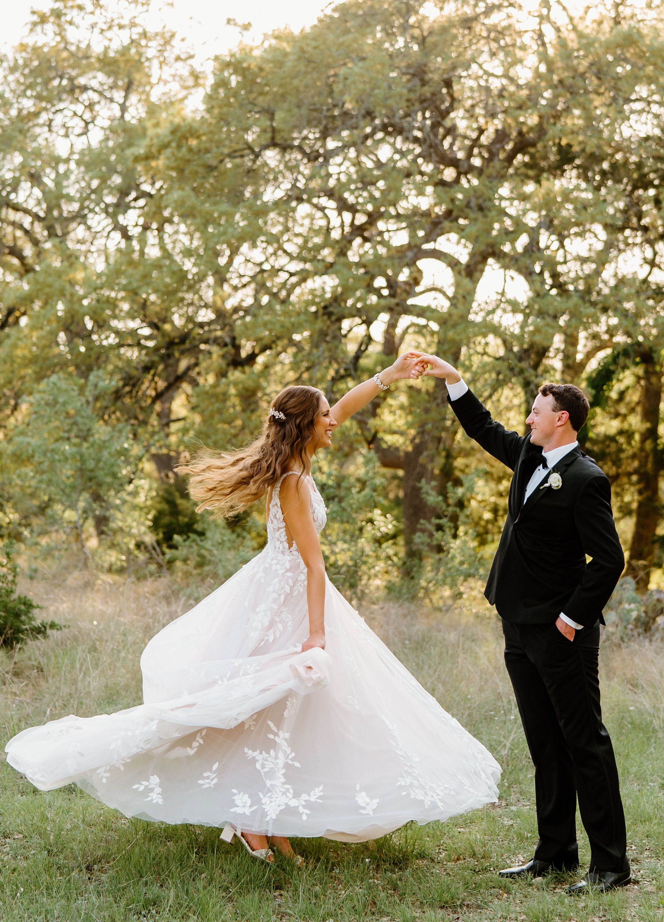 A groom twirls his new bride as her floral-adorned dress flares out revealing her sparkly block heels.