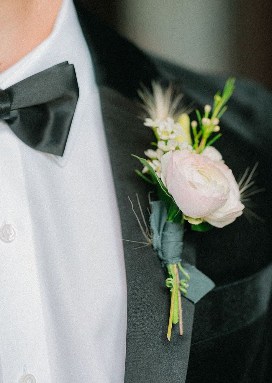 Groom wears an artfully designed boutonnière for the southern styled shoot.