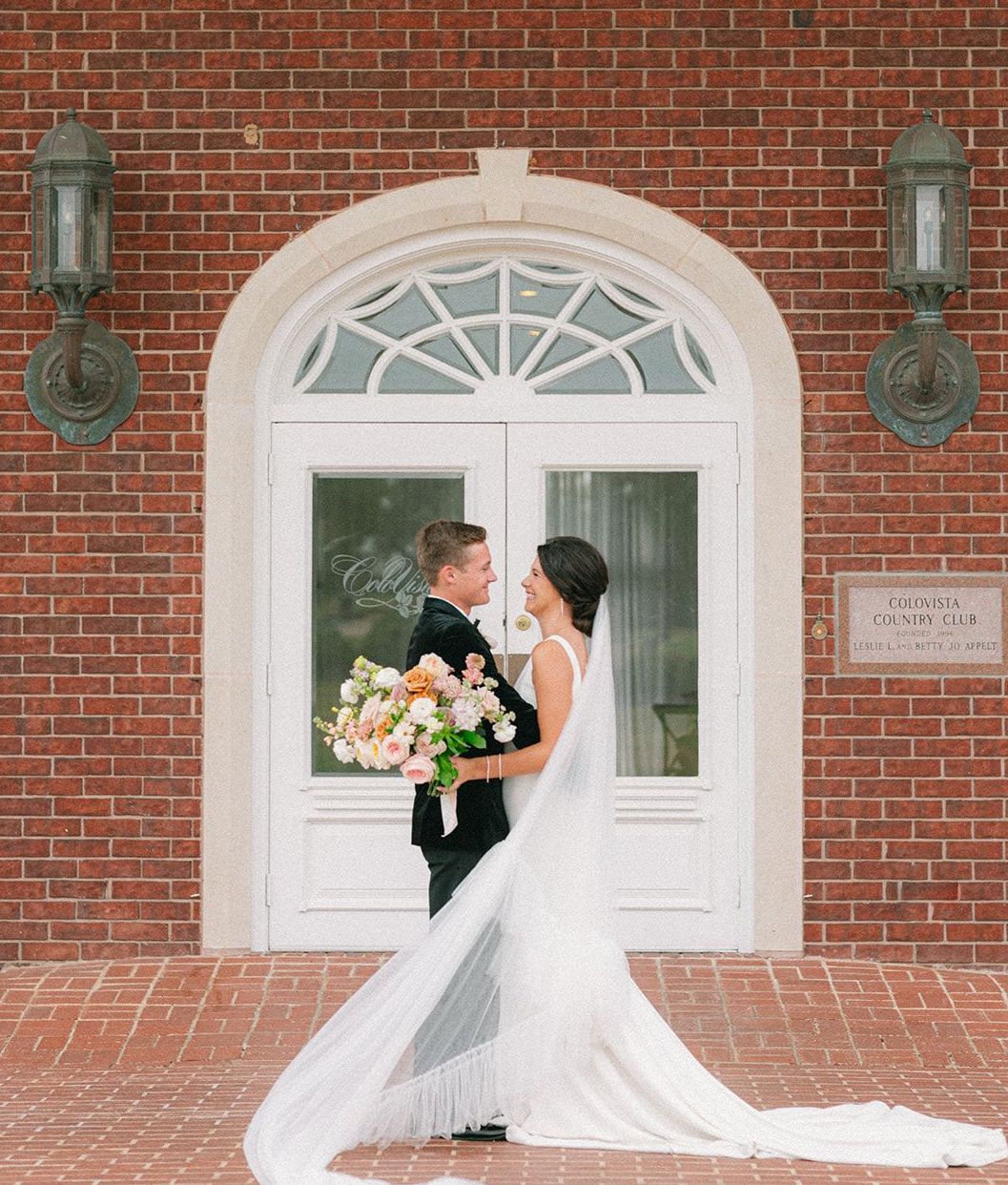 Bride and groom smile at each in front of The Mansion at ColoVista for the southern styled shoot.