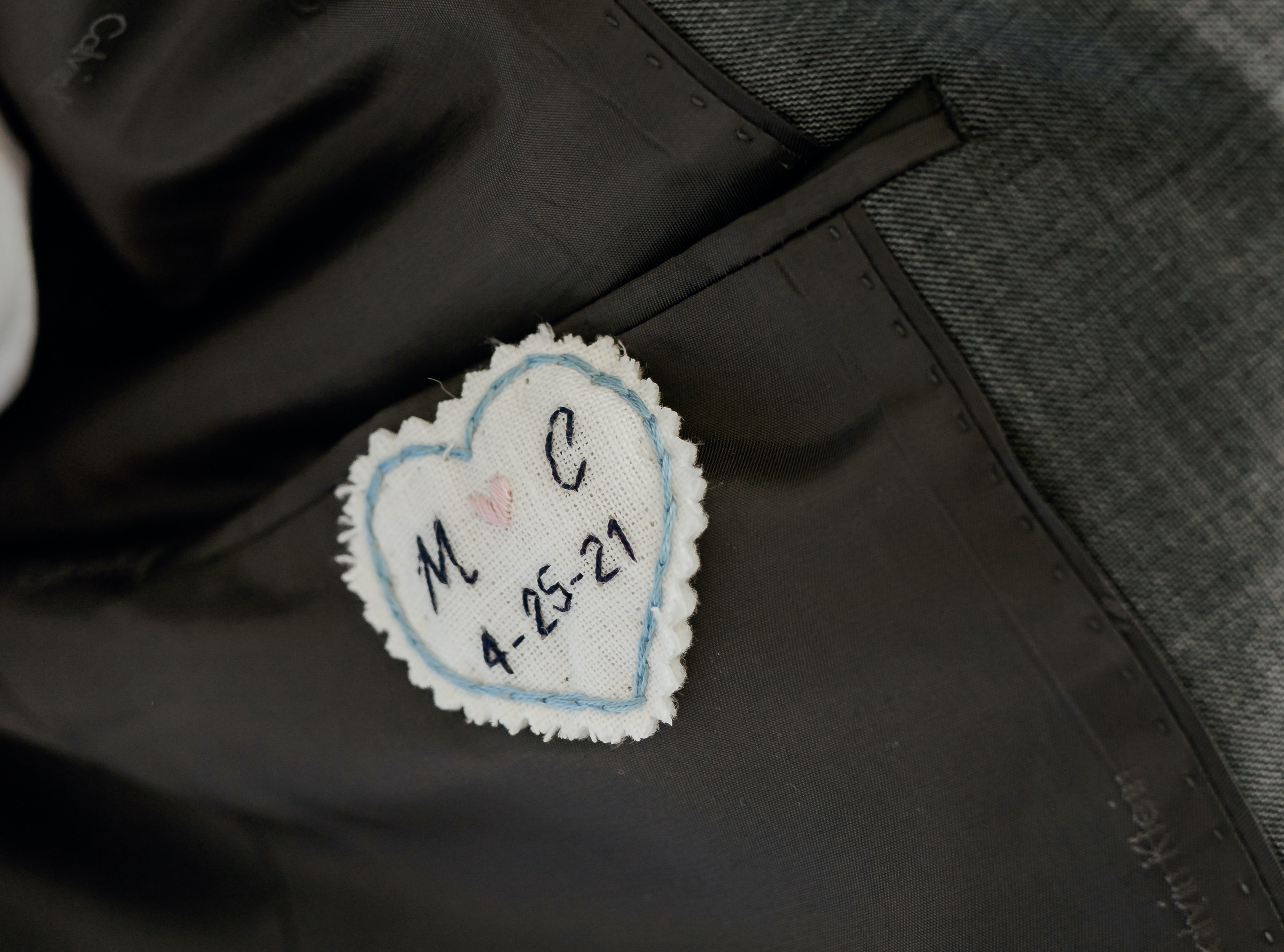 An embroidered heart inside the groom's suitcoat.