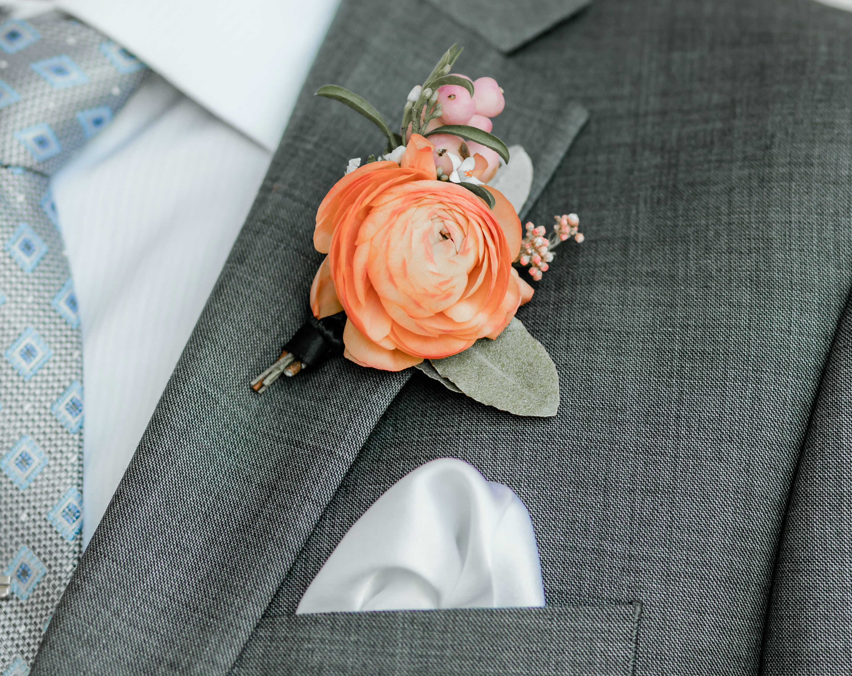 The groom's vibrant orange boutonierre. 