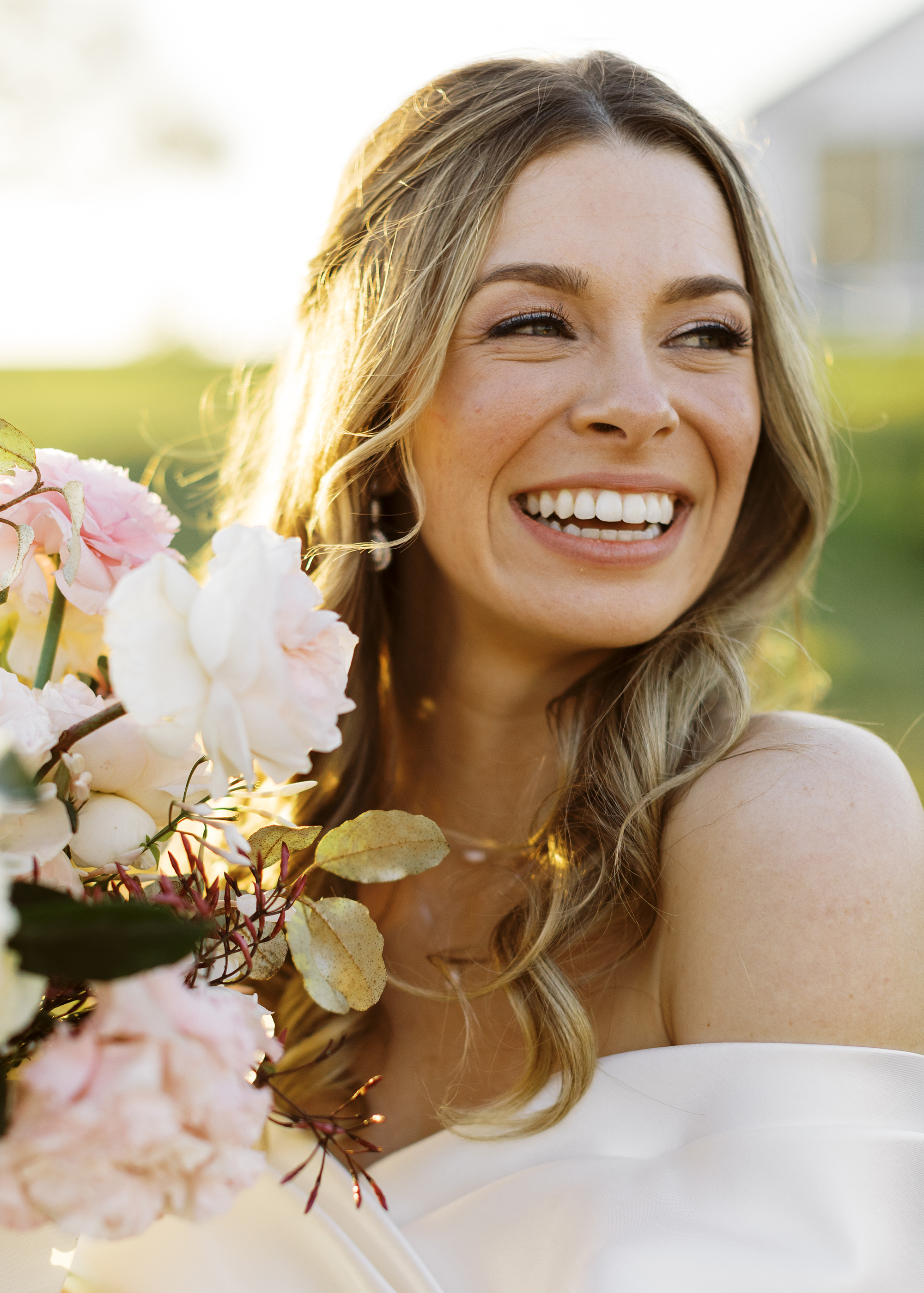 The bride is smiling while holding her bridal bouquet.