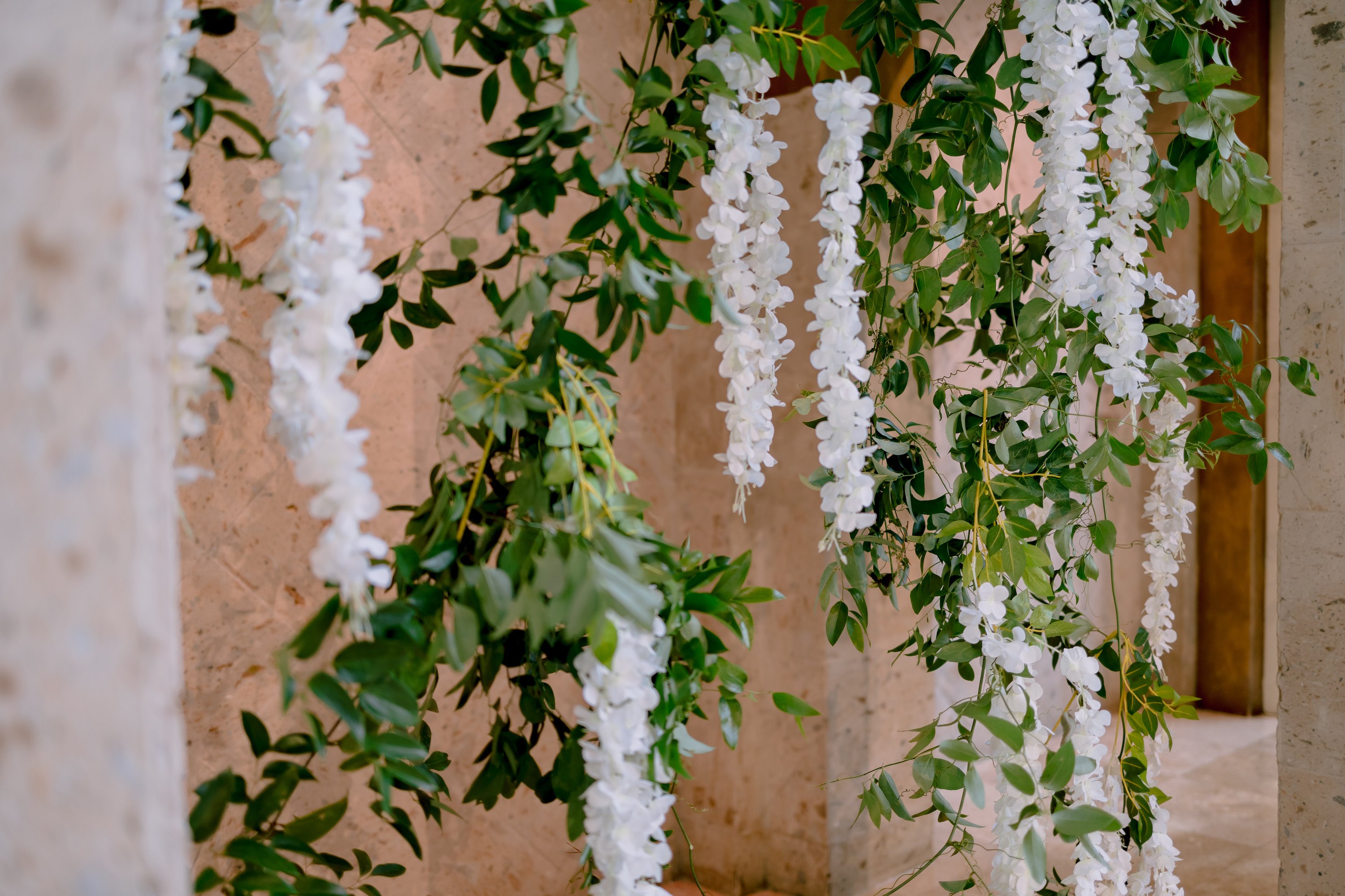 White wisteria hangs from the altar of the greenery-filled wedding.