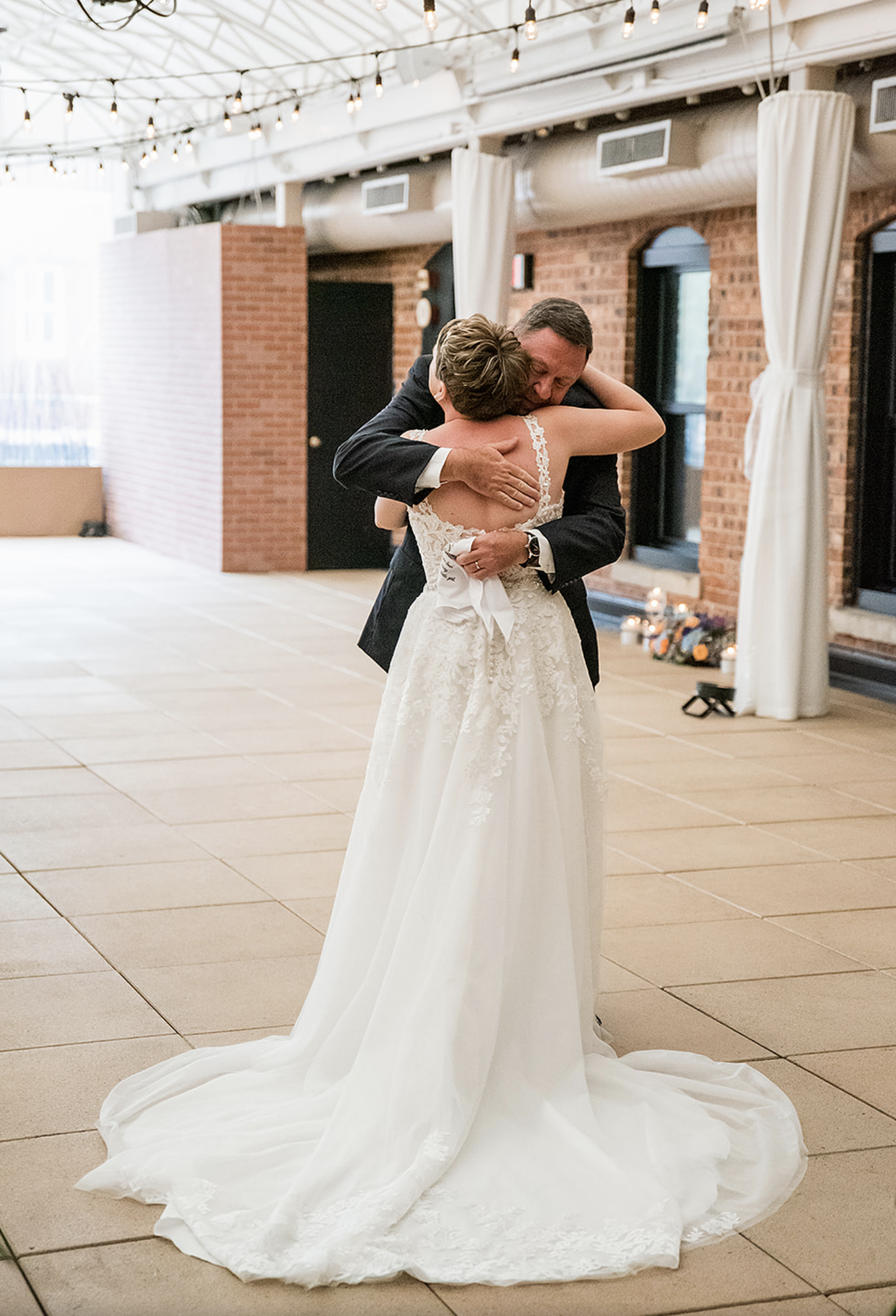 The bride hugs her dad before the ceremony of the whimsical jewel-toned wedding starts.