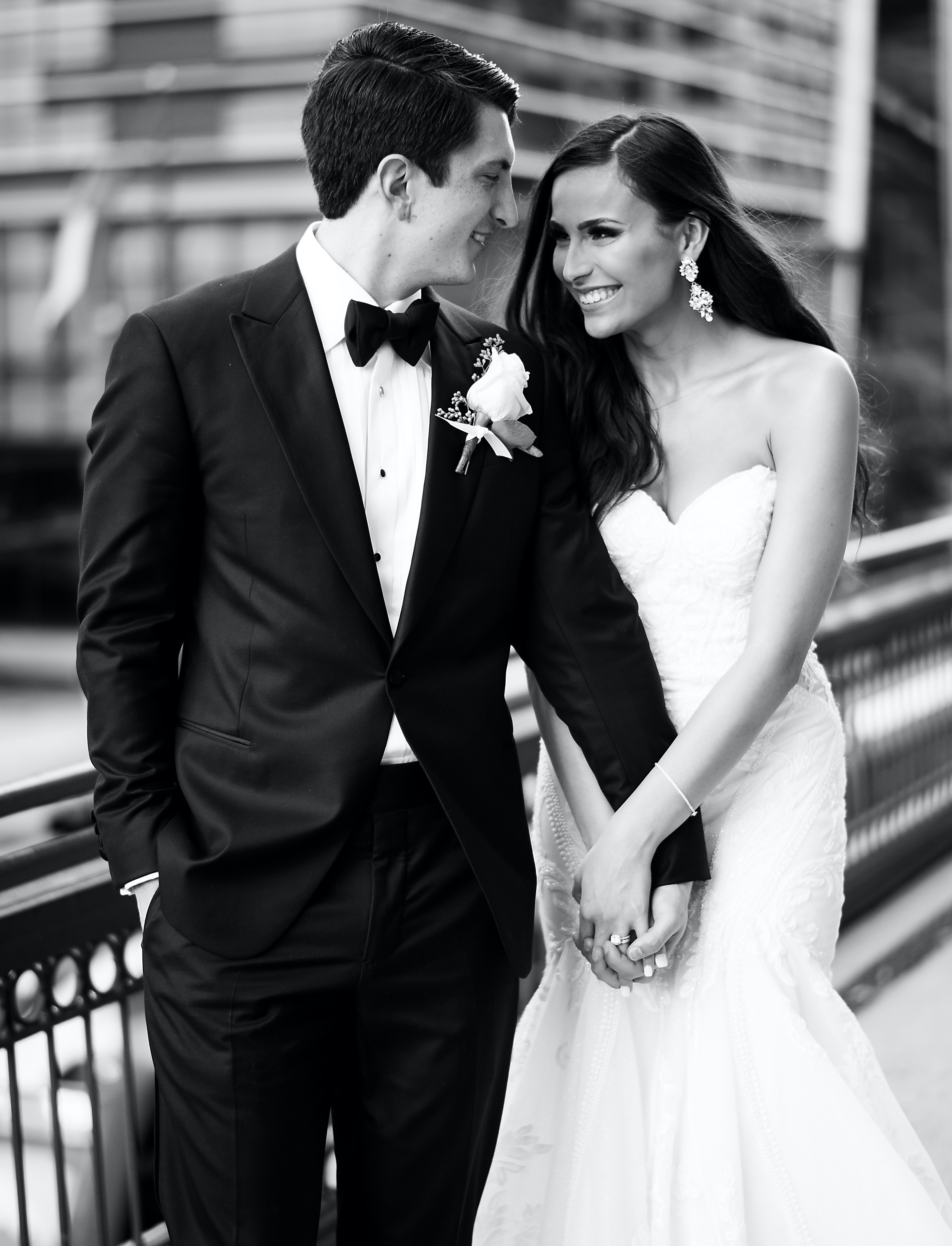 The bride and groom look at each other and hold hands on the terrace.