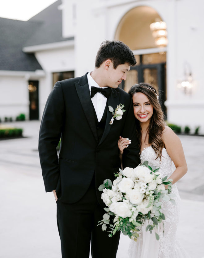 The bride and groom stand in front of The Peach Orchard, their wedding venue