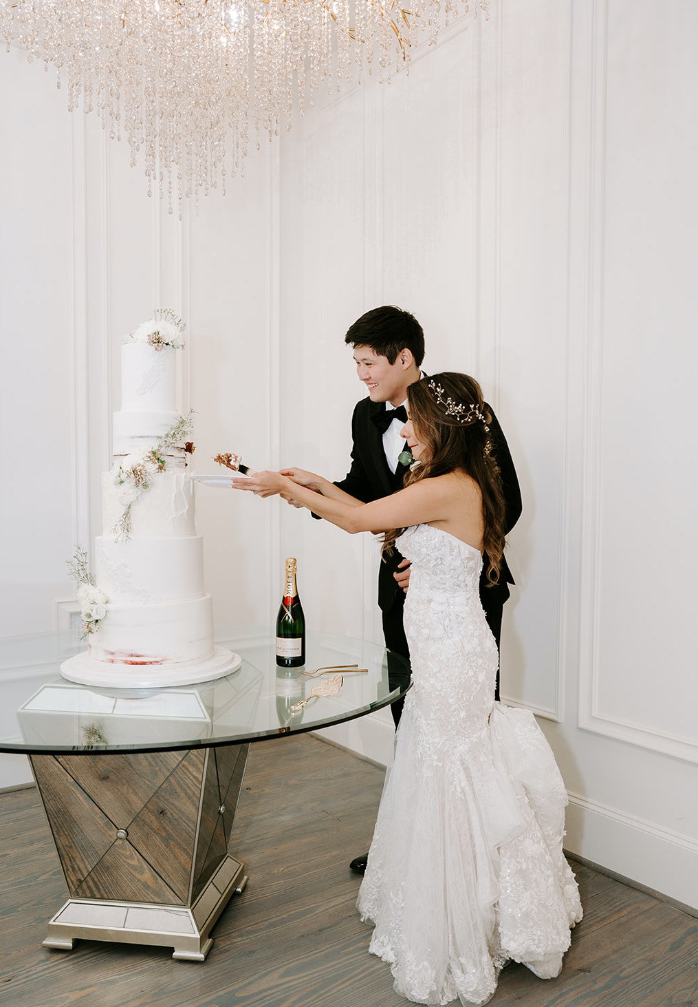 The bride and groom cut into a 5-tiered cake at their wedding reception at the Peach Orchard Venue. 