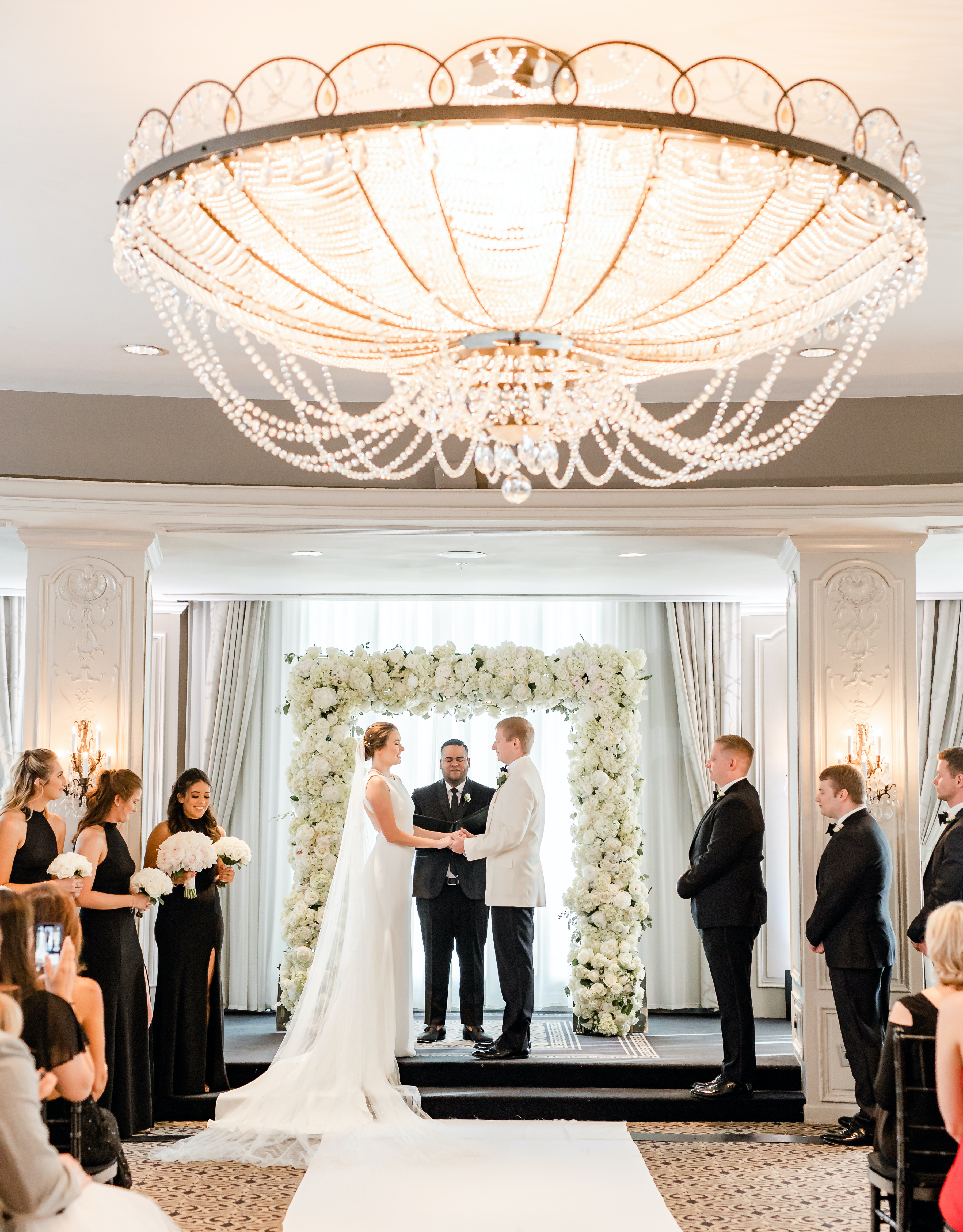 The bride and groom stand at the altar holding hands for their wedding ceremony in the Houston museum district.