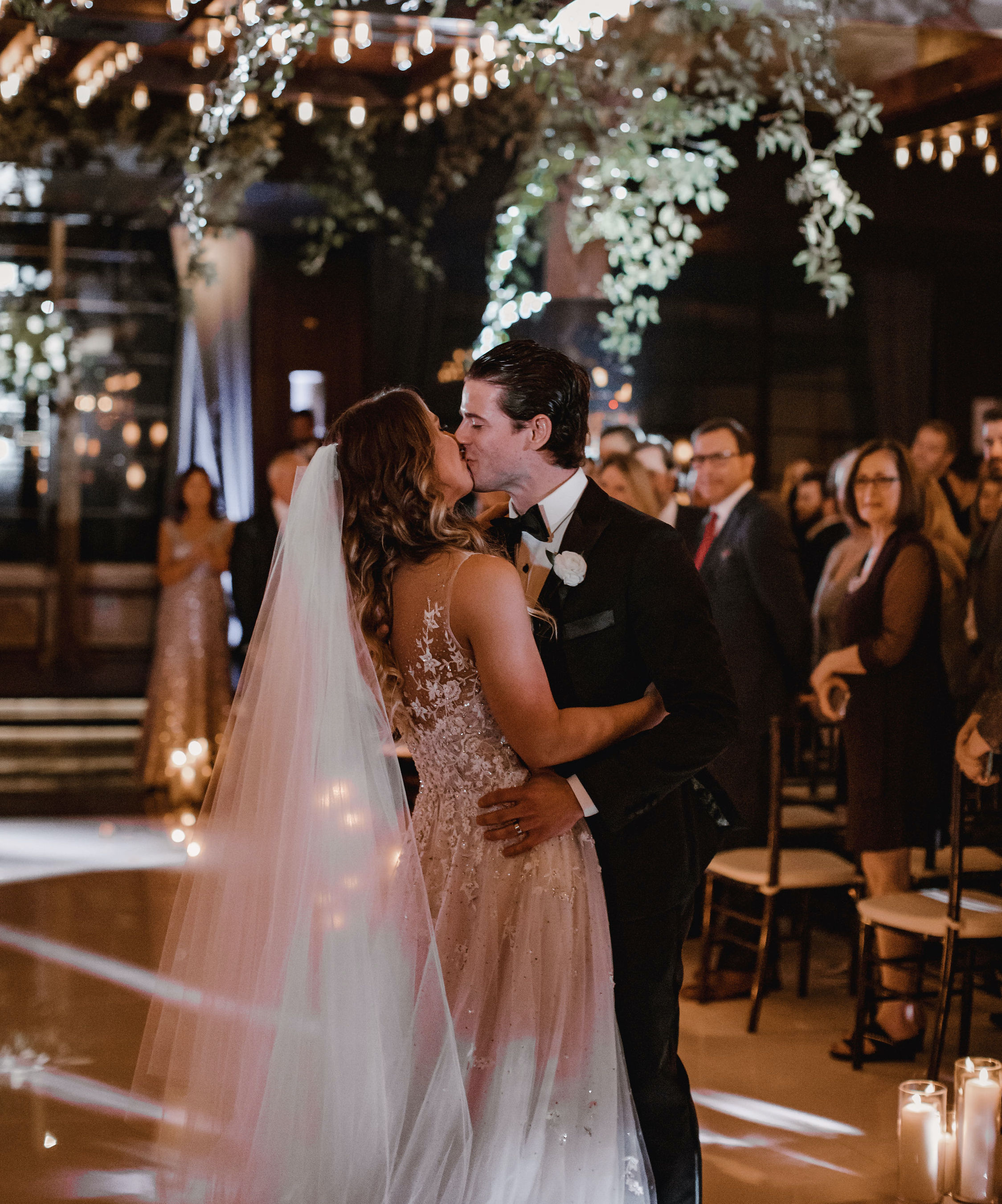 The bride and groom kiss in the middle of the aisle at their wedding at The Astorian in Houston, TX.