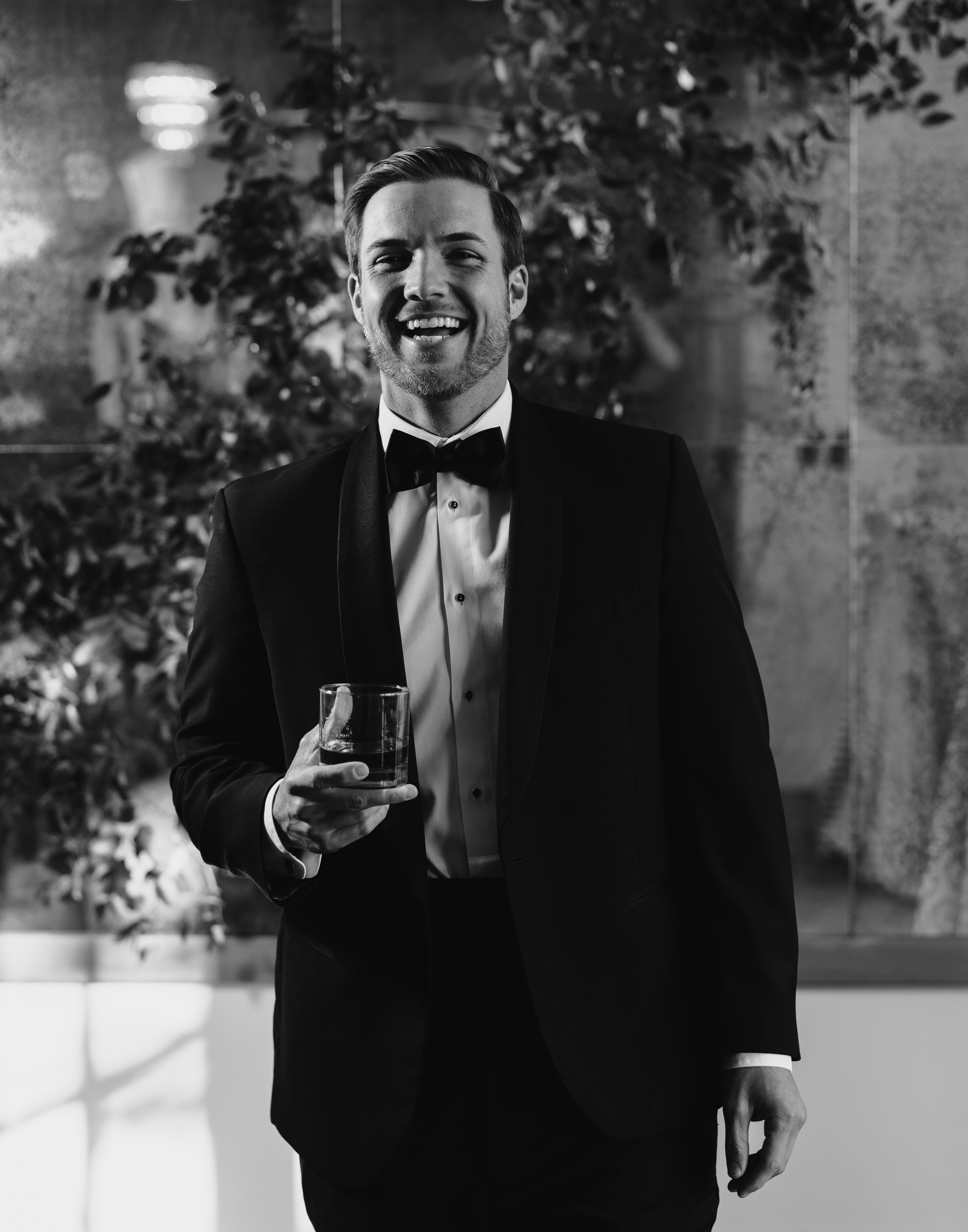 Bachelor Nation's Jordan Kimball holds a cocktail and laughs at the camera during his wedding reception in Houston, TX.