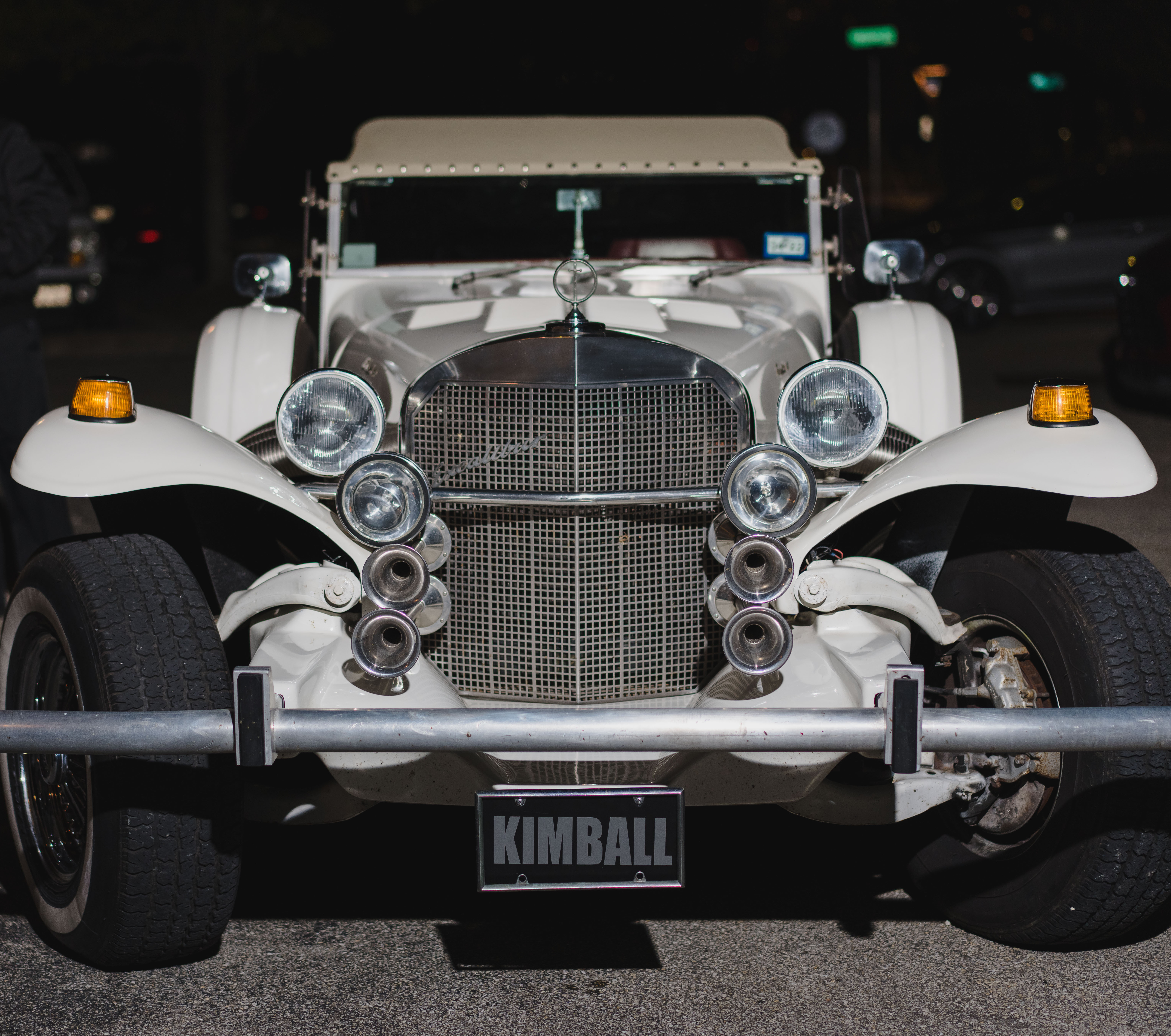 A vintage white car with a custom license plate that reads "Kimball" for Jordan Kimball's wedding in Houston, TX.