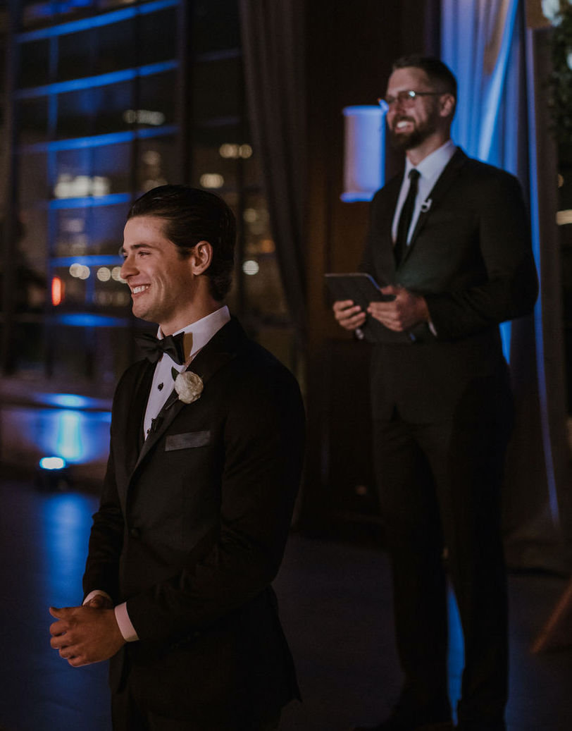 The groom tears up as we watches his bride walk down the aisle as they celebrate their love story at The Astorian, a wedding venue in Houston TX.