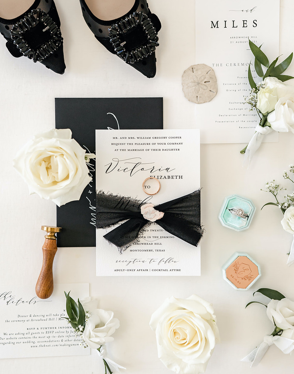 A flatlay for an elegant summer wedding in Montgomery, Texas with white, black and gold accents.