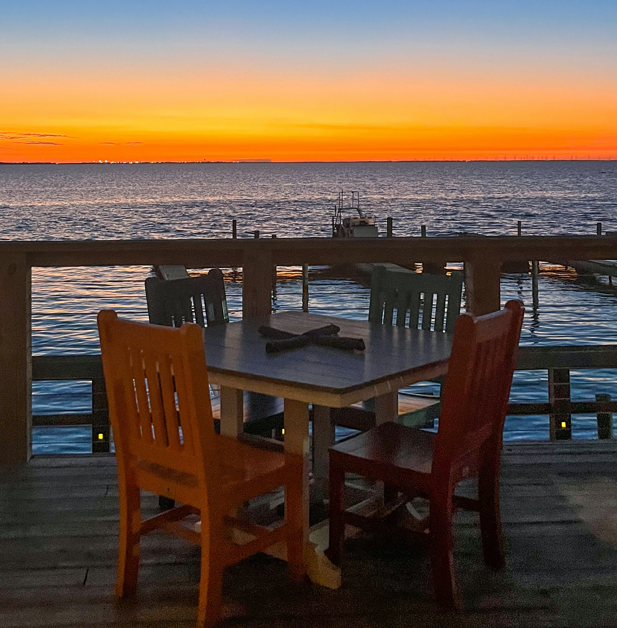 The sunset leaves the sky bright orange over the bay in South Padre Island at The Painted Marlin Grille.