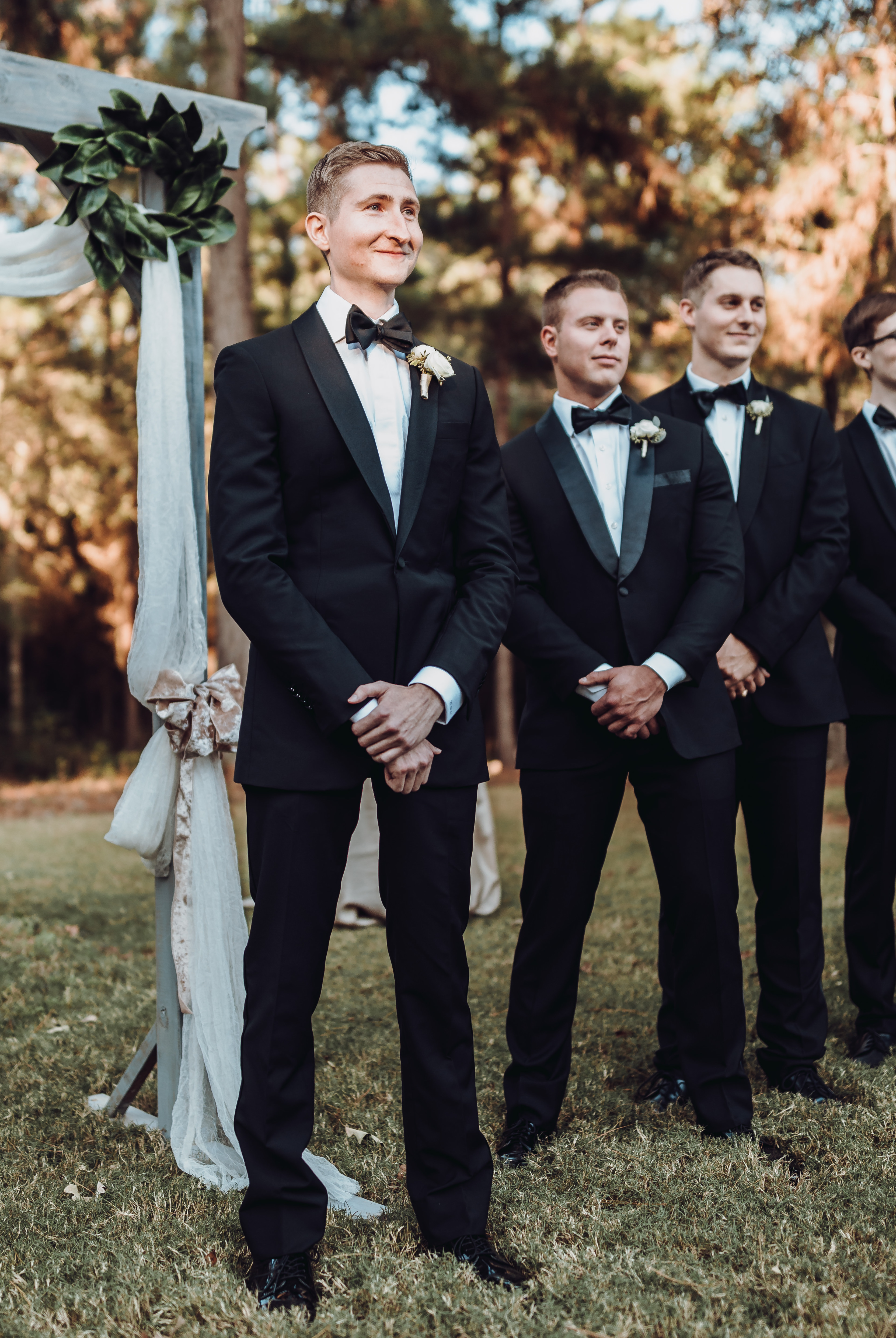 A groom sees his bride walk down the aisle at their backyard wedding ceremony in Houston, TX.