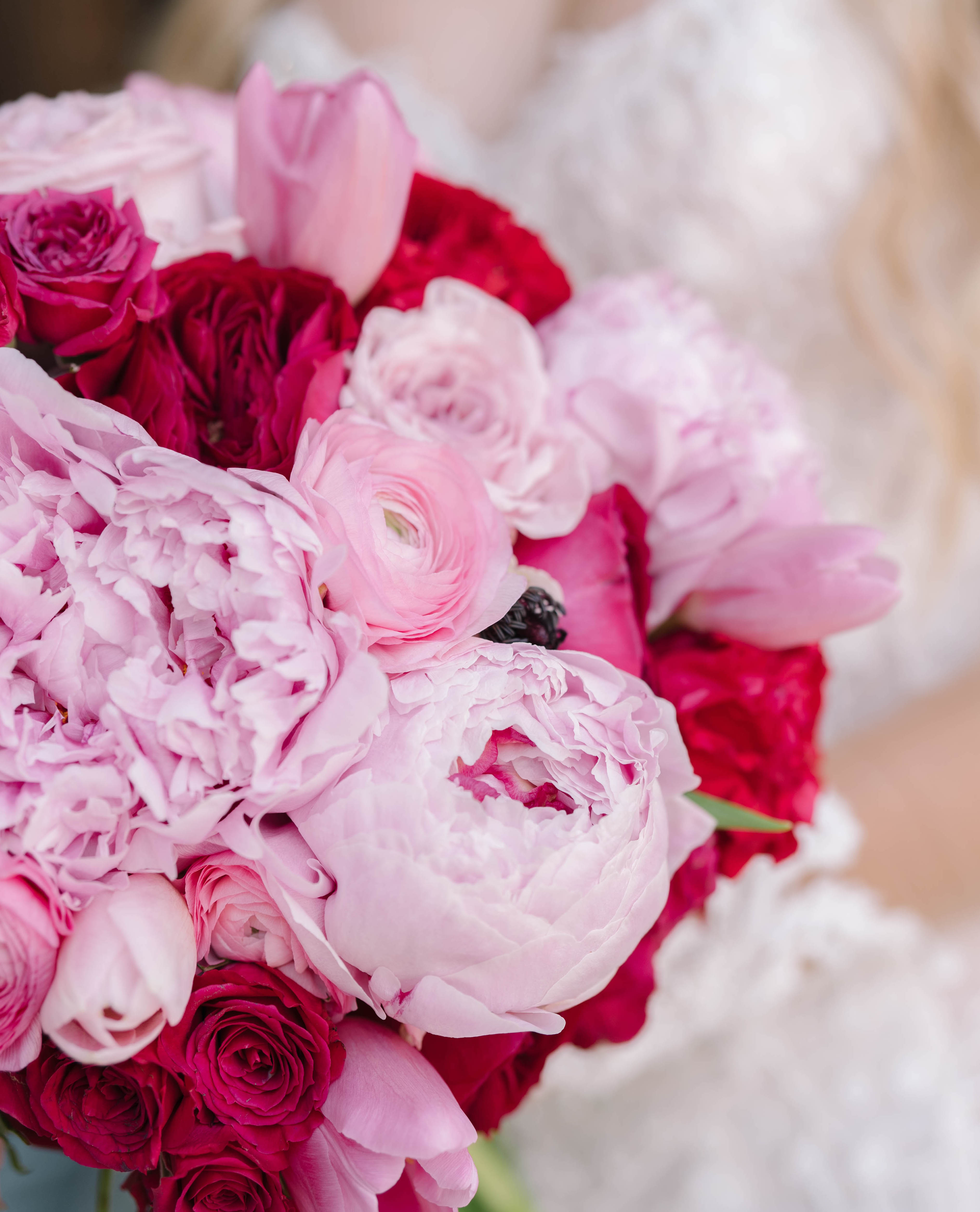 A bright pink bridal bouquet with pink peonies, ranunculus and tulips.