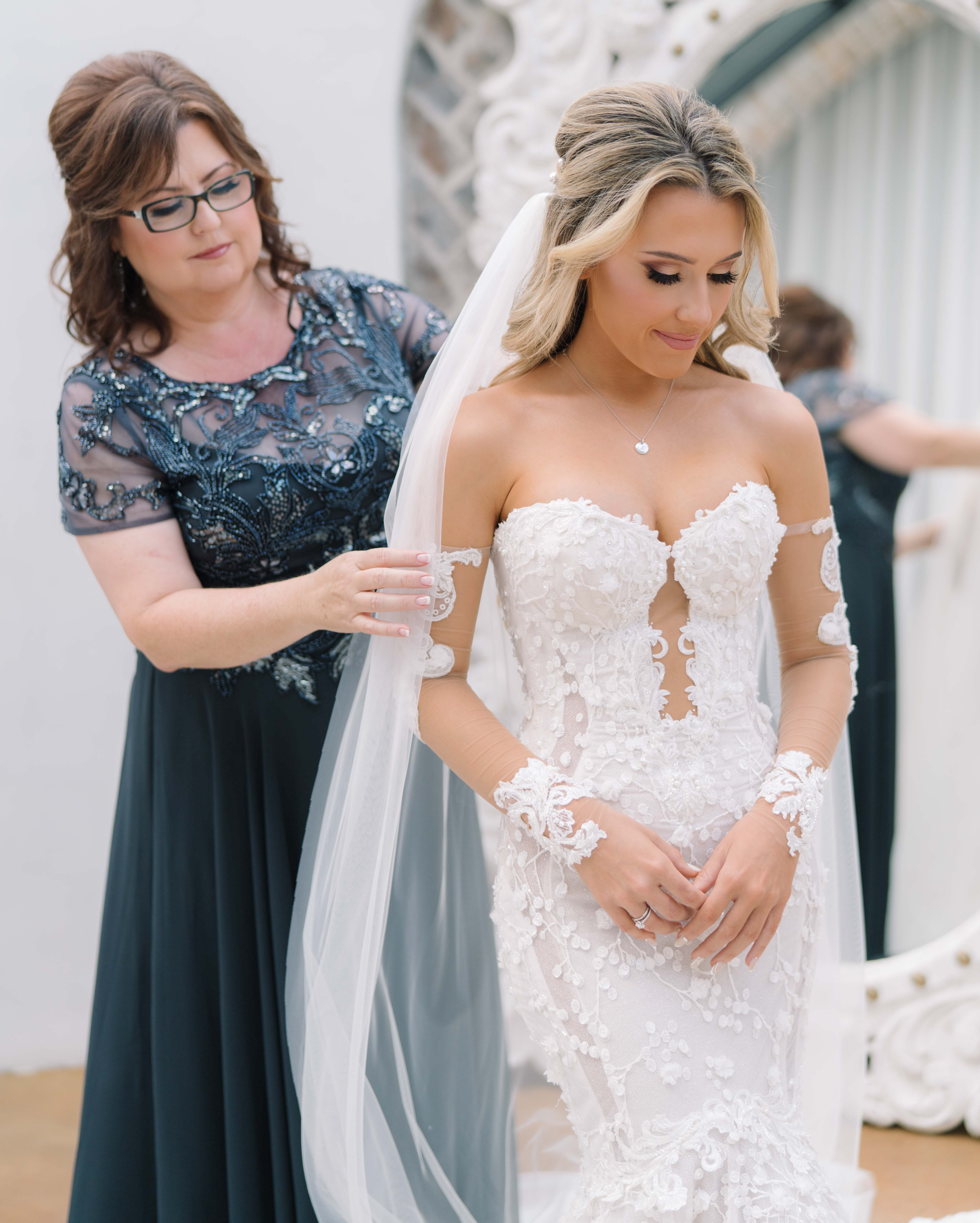 A bride's mom helps the bride with her veil before her wedding ceremony in Conroe, TX.