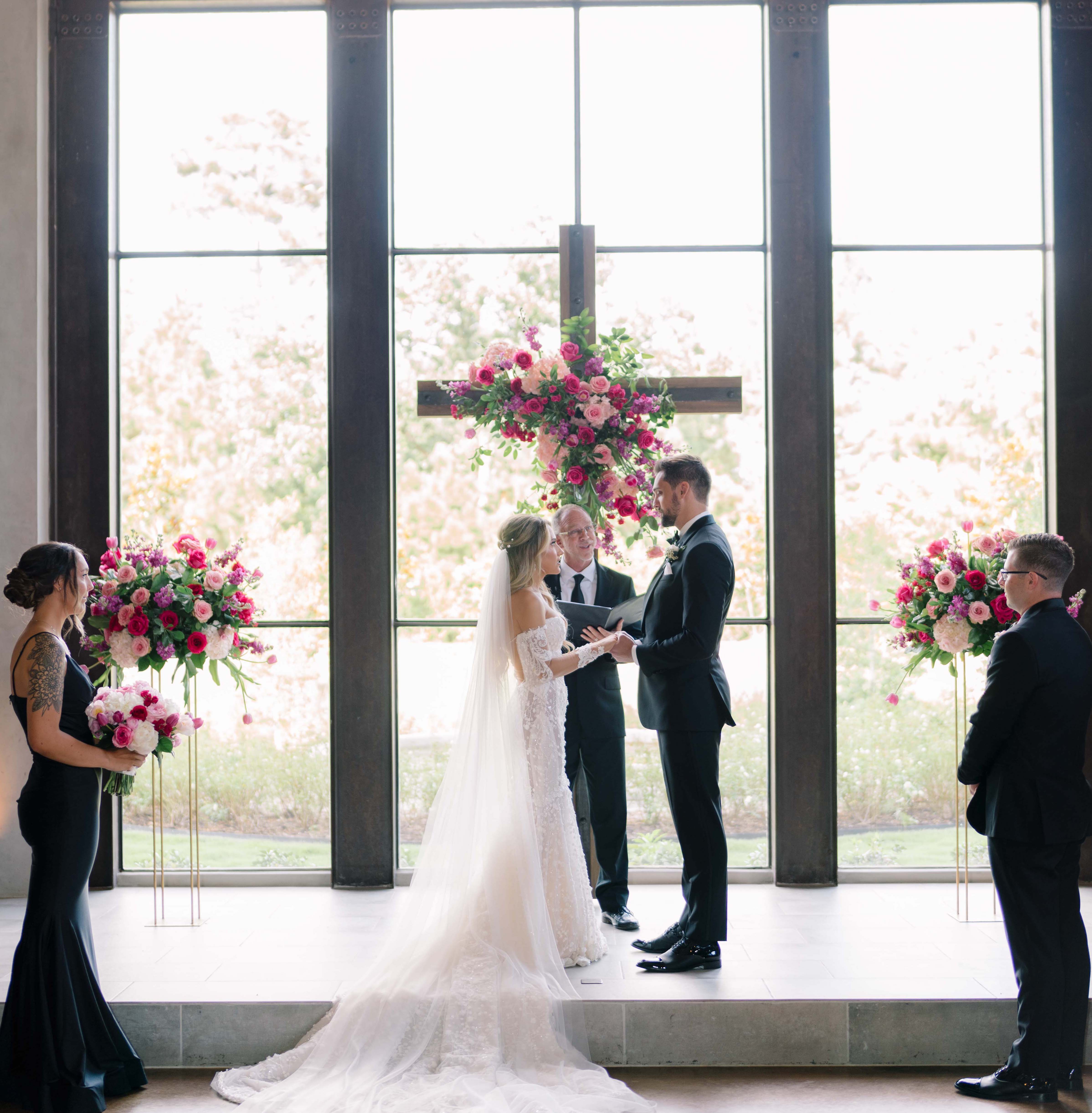 A bride and groom hold each other's hands at the altar during their wedding ceremony in Conroe, TX which is north of Houston.