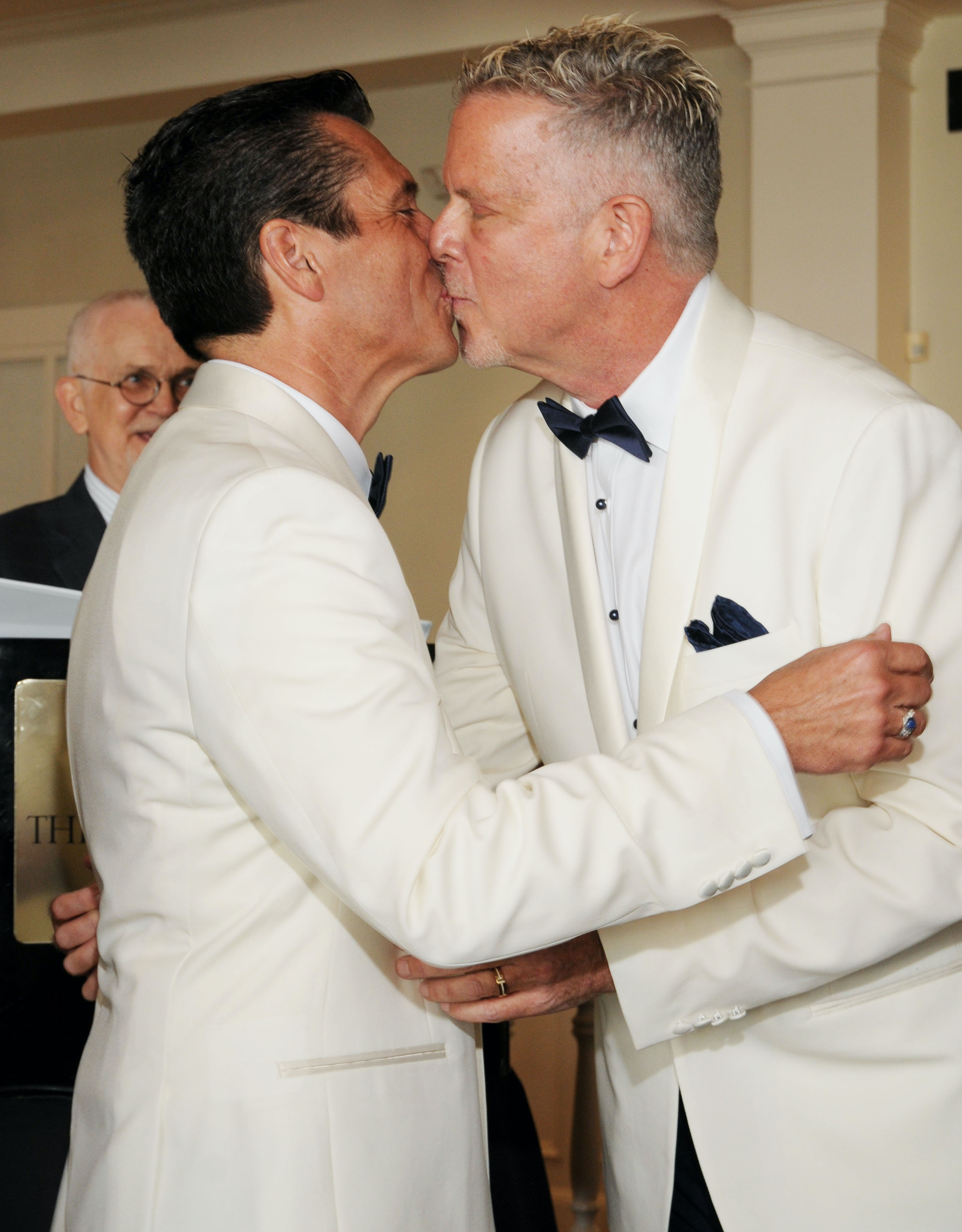 A groom and groom kiss at their wedding ceremony in Galveston, TX.