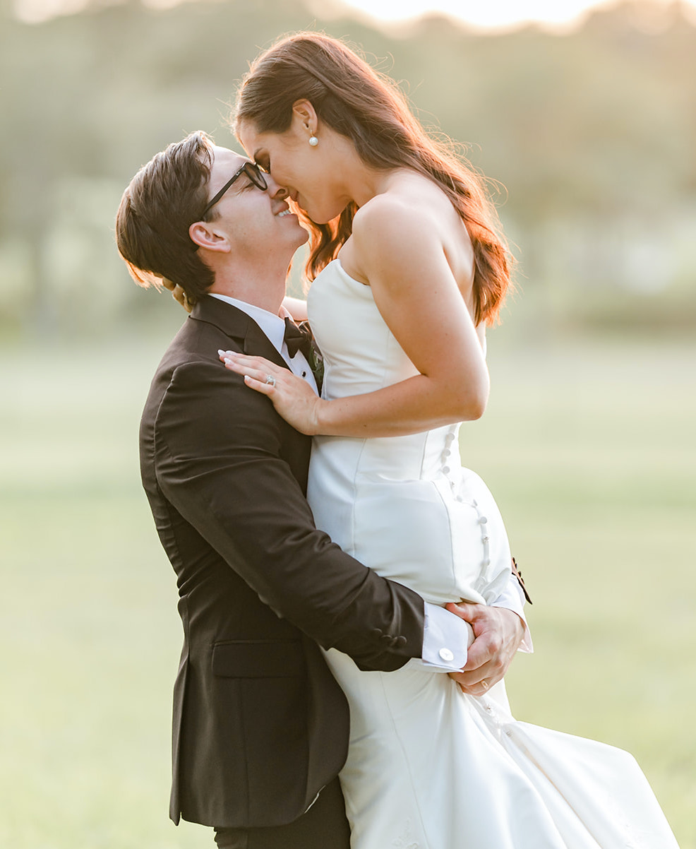 Bride and groom hug each other outside during their elegant summer wedding in Montgomery, Texas.