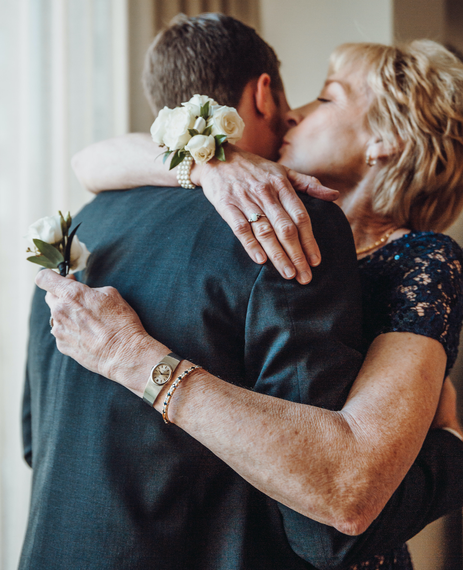 A groom hugs his mom before his modern music hall wedding in Houston, TX.