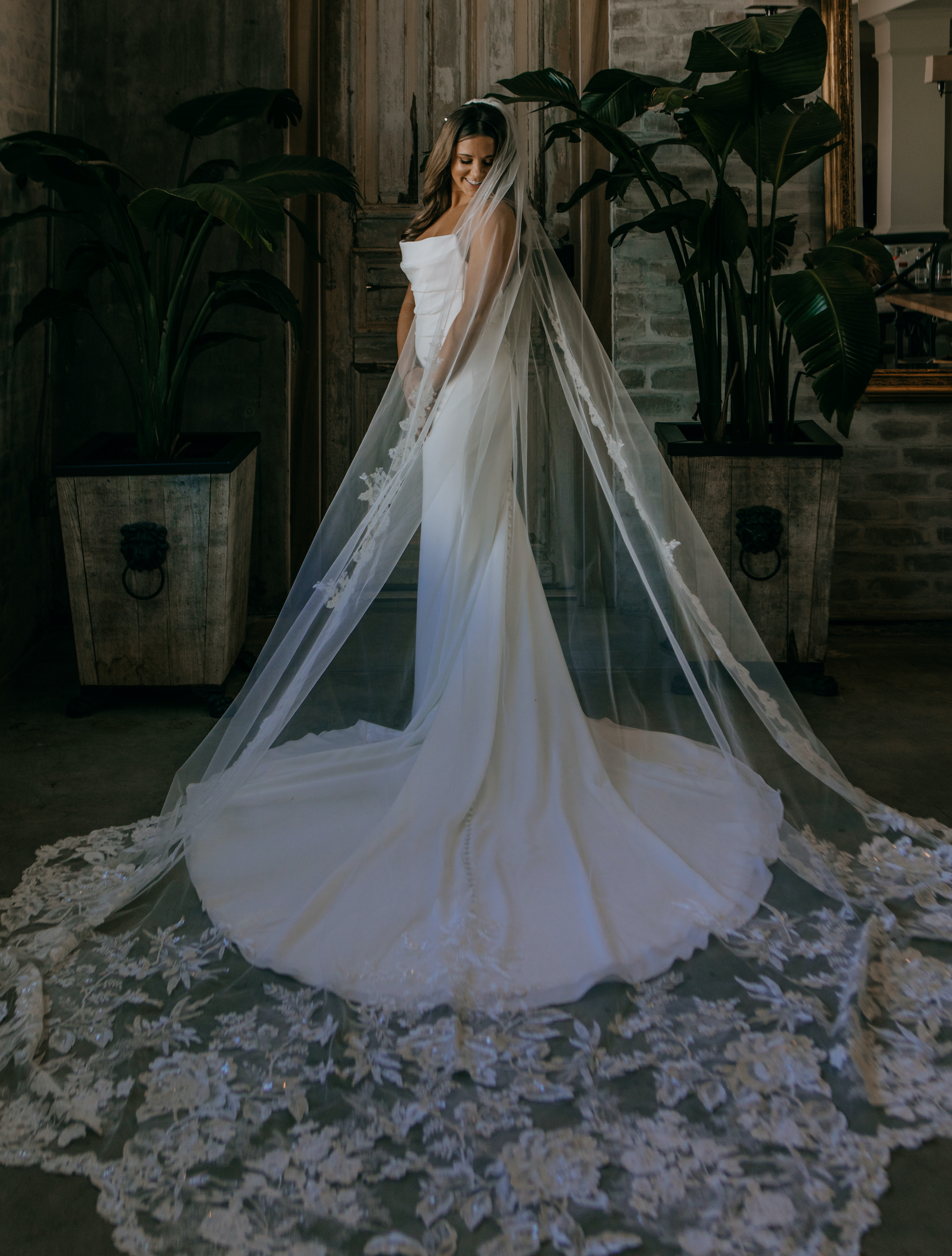 A bride looks down at her wedding dress before her ceremony in Houston, TX.