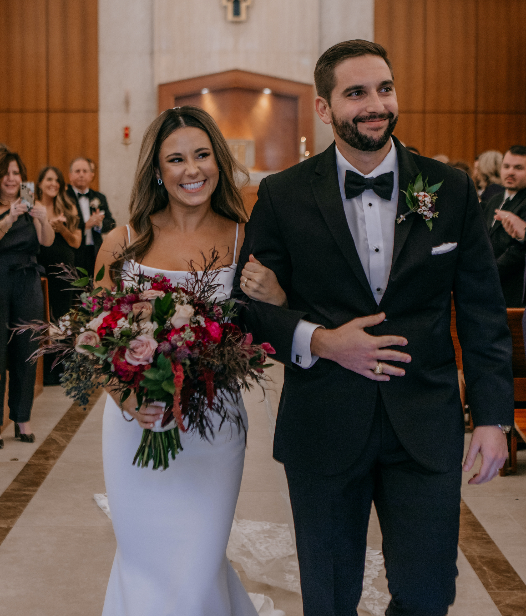 A bride walks down the aisle with her groom and they head to their wedding reception at The Astorian. Jewel Toned Wedding With Art Deco Vibes