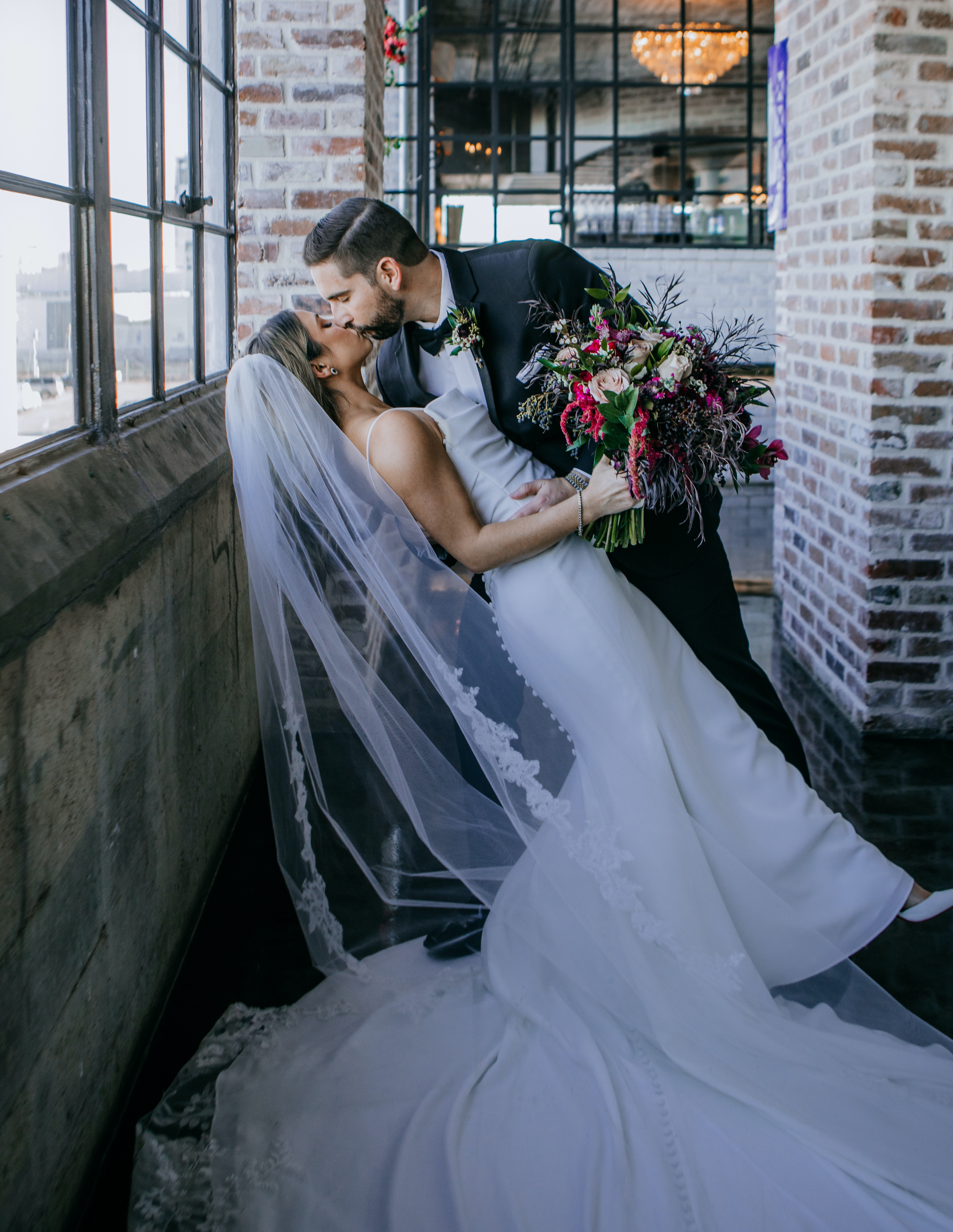 A bride and groom kiss at their wedding venue at The Astorian before their reception.