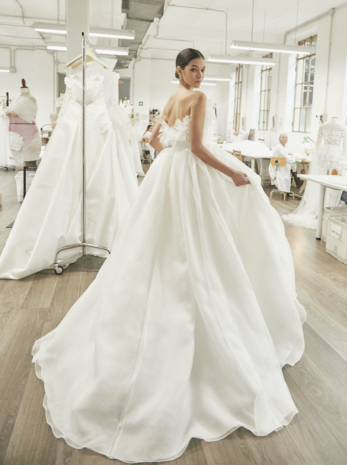 A model wears a strapless full wedding gown with a ruffle trim on the bust. Designed by Peter Langner for wedding gowns for the spring and summer