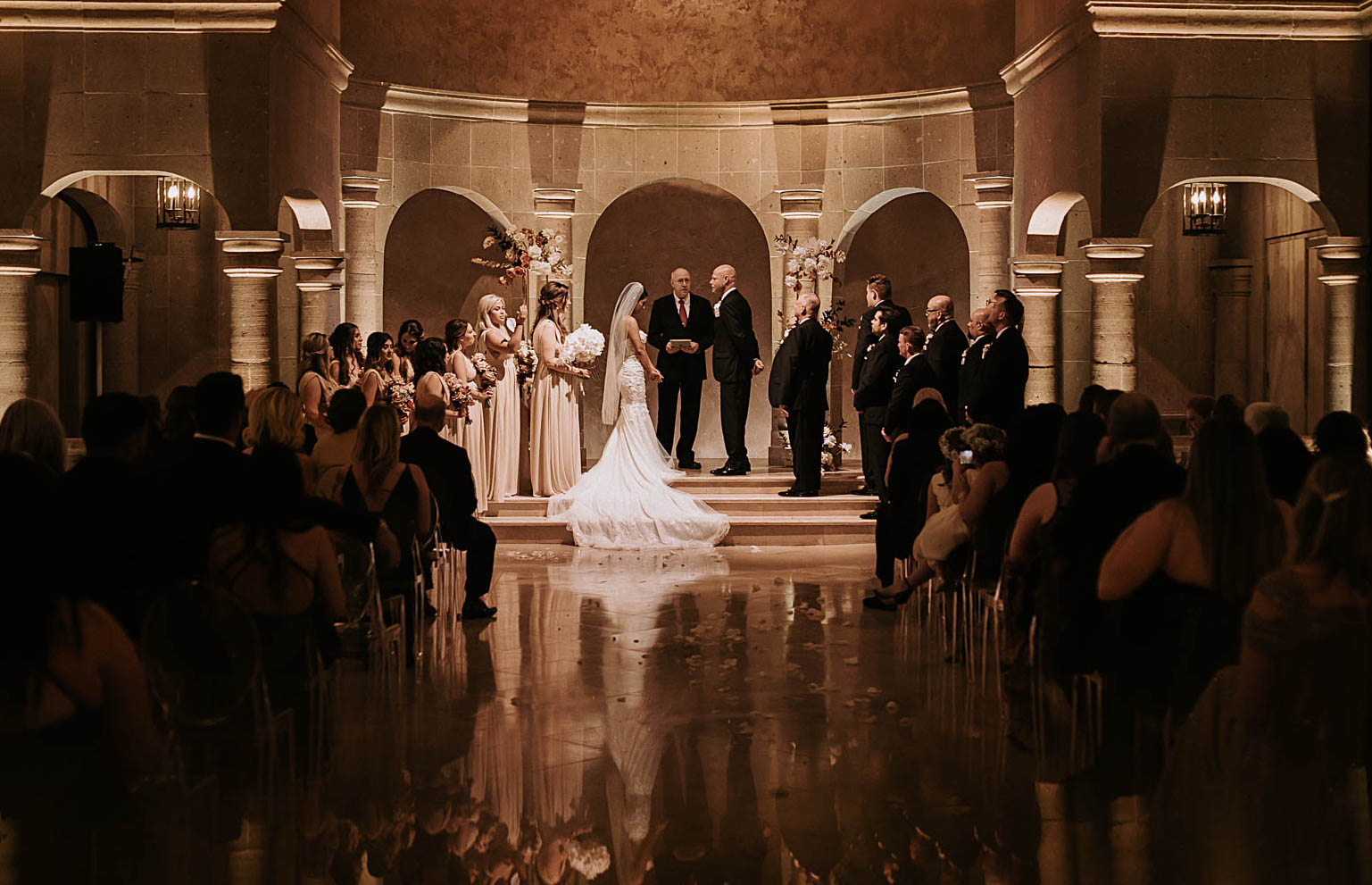 A bride and groom stand at the altar for their wedding ceremony at The Bell Tower on 34th in Houston, TX.