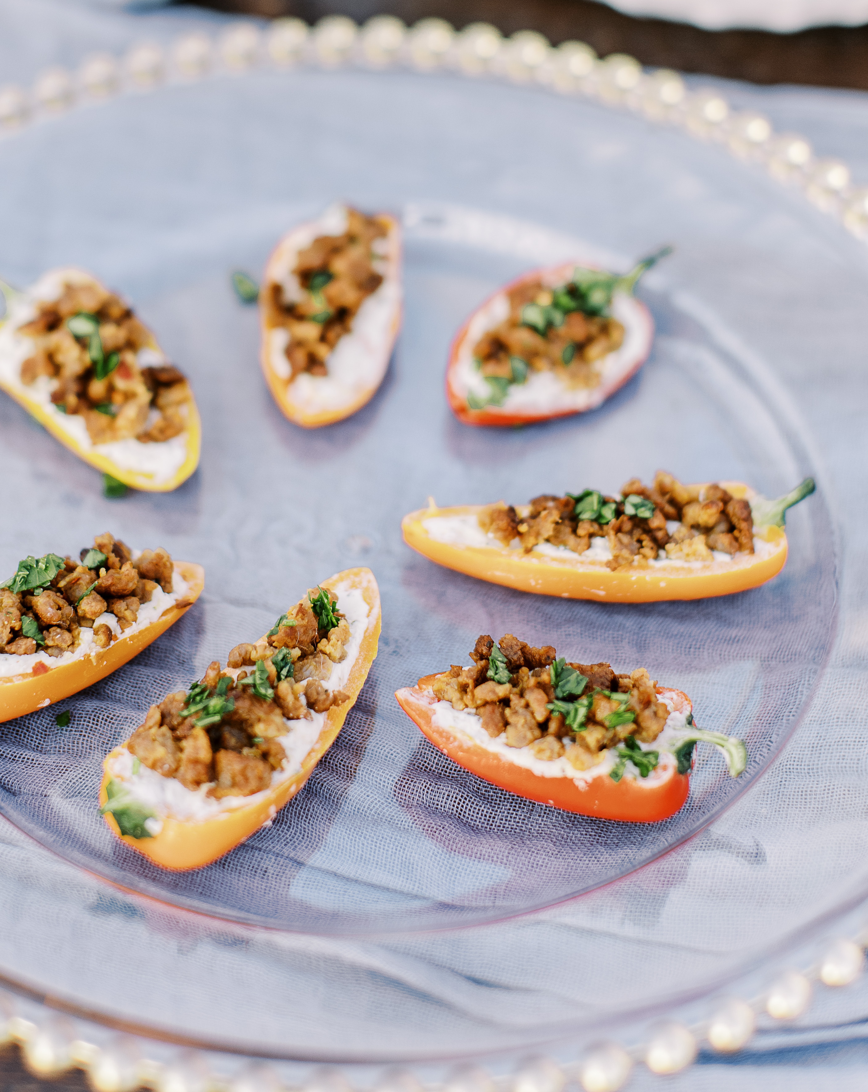 Mini stuffed bell peppers are on a serving dish for a cocktail party before a sunlit hill country wedding reception.