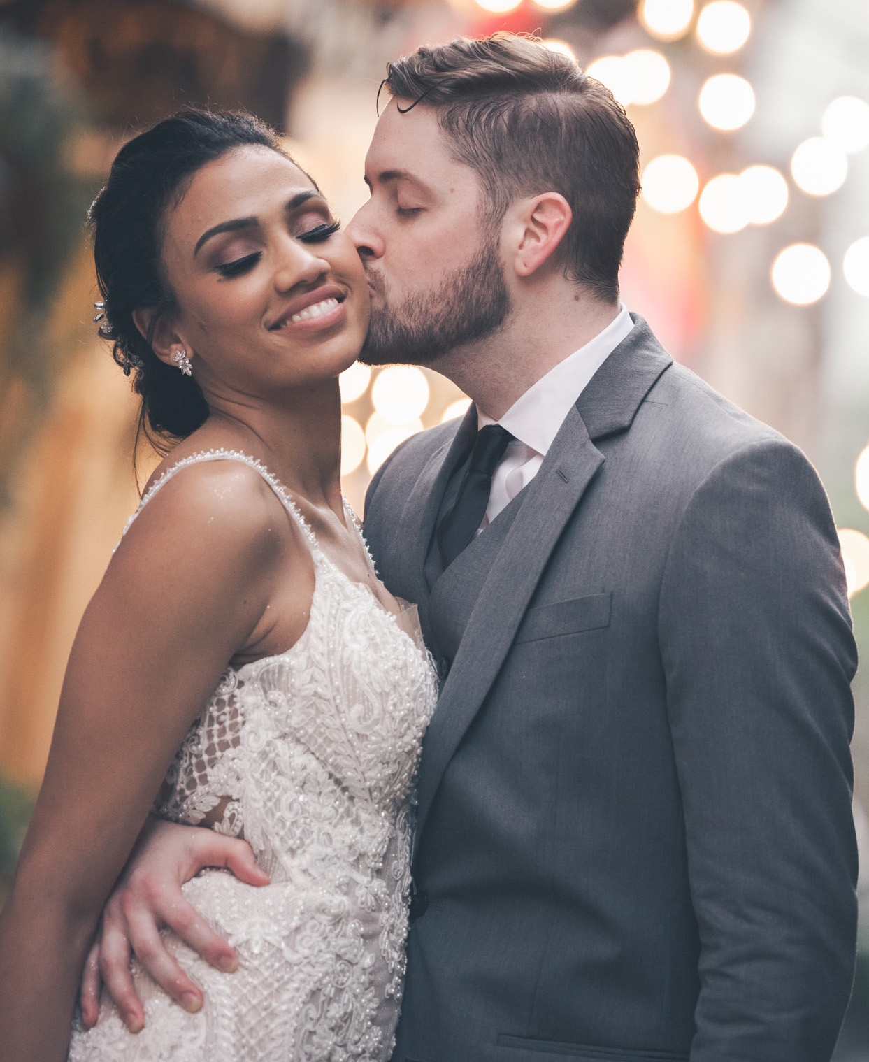 A groom kisses his bride on the cheek on their wedding day in New Orleans.