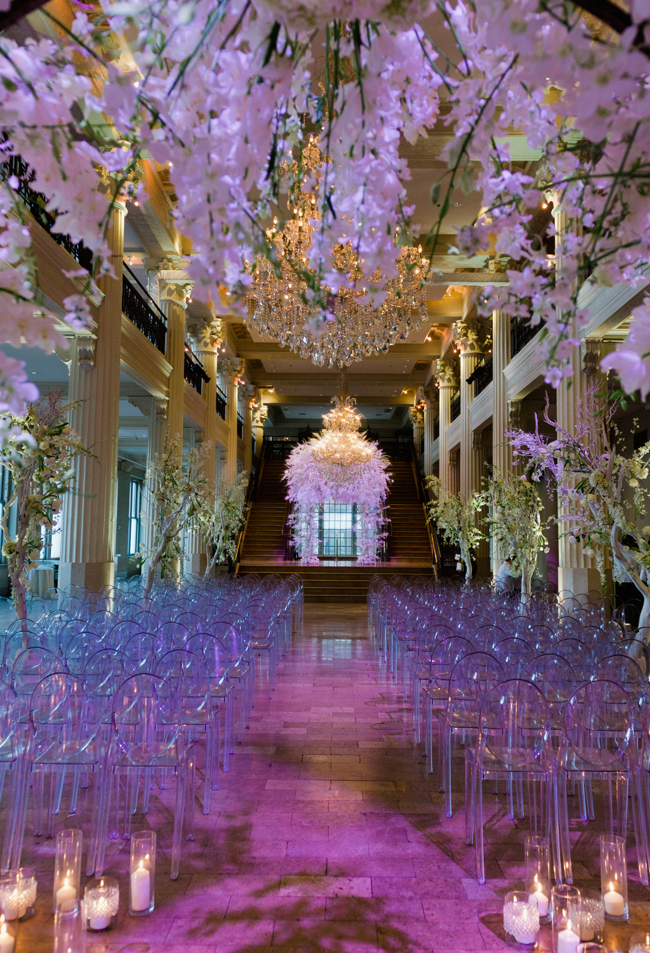 The Corinthian Houston is decorated with elegant flower installations with white flowers and a magenta light illuminating the ceremony space.