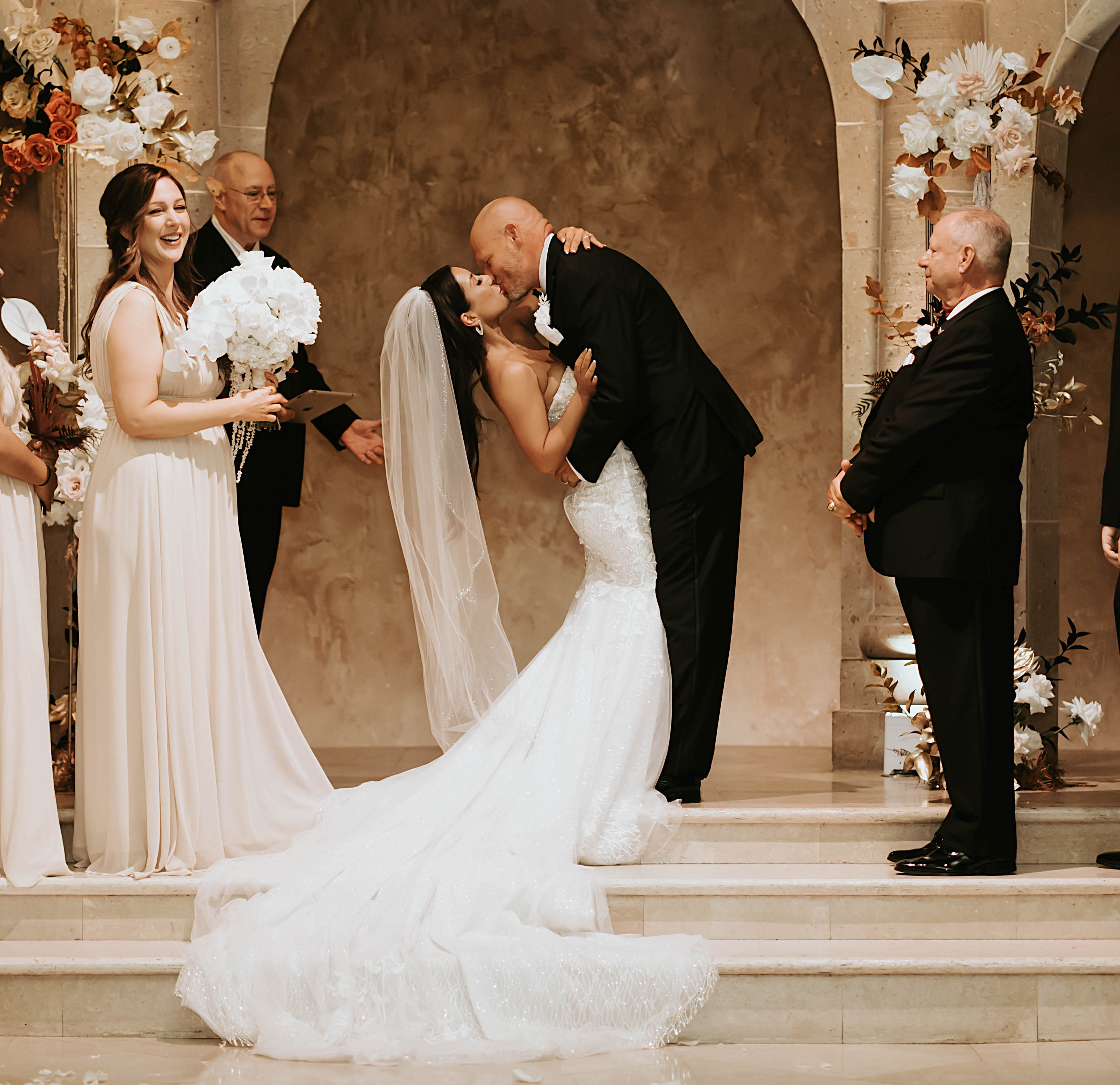 A groom kisses his bride at The Bell Tower on 34th in Houston, TX.