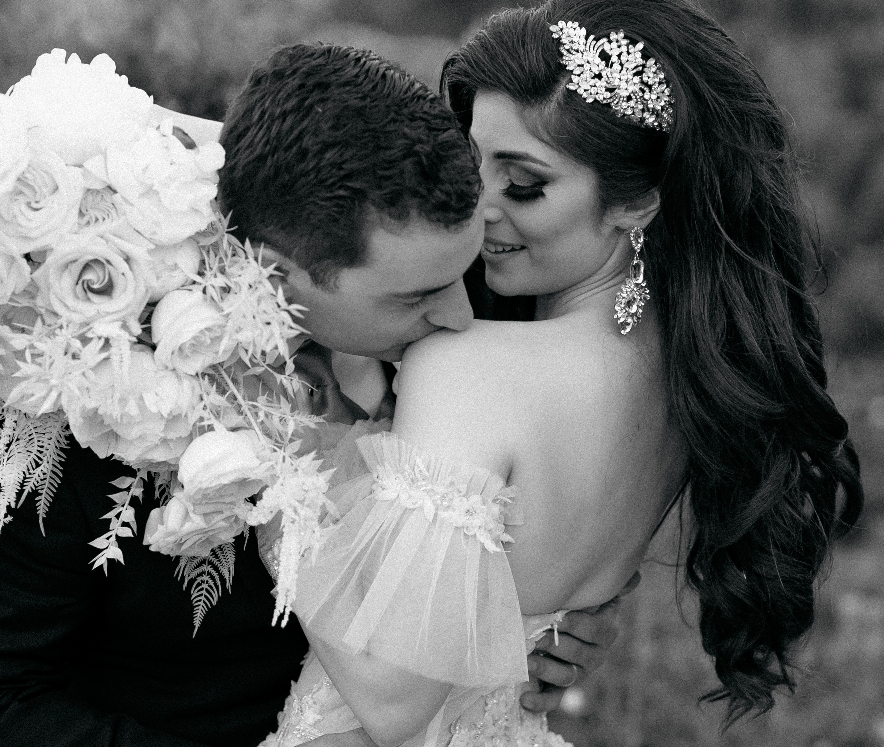 A black and white photo of a bride and groom hugging on their wedding day in Montgomery, TX.