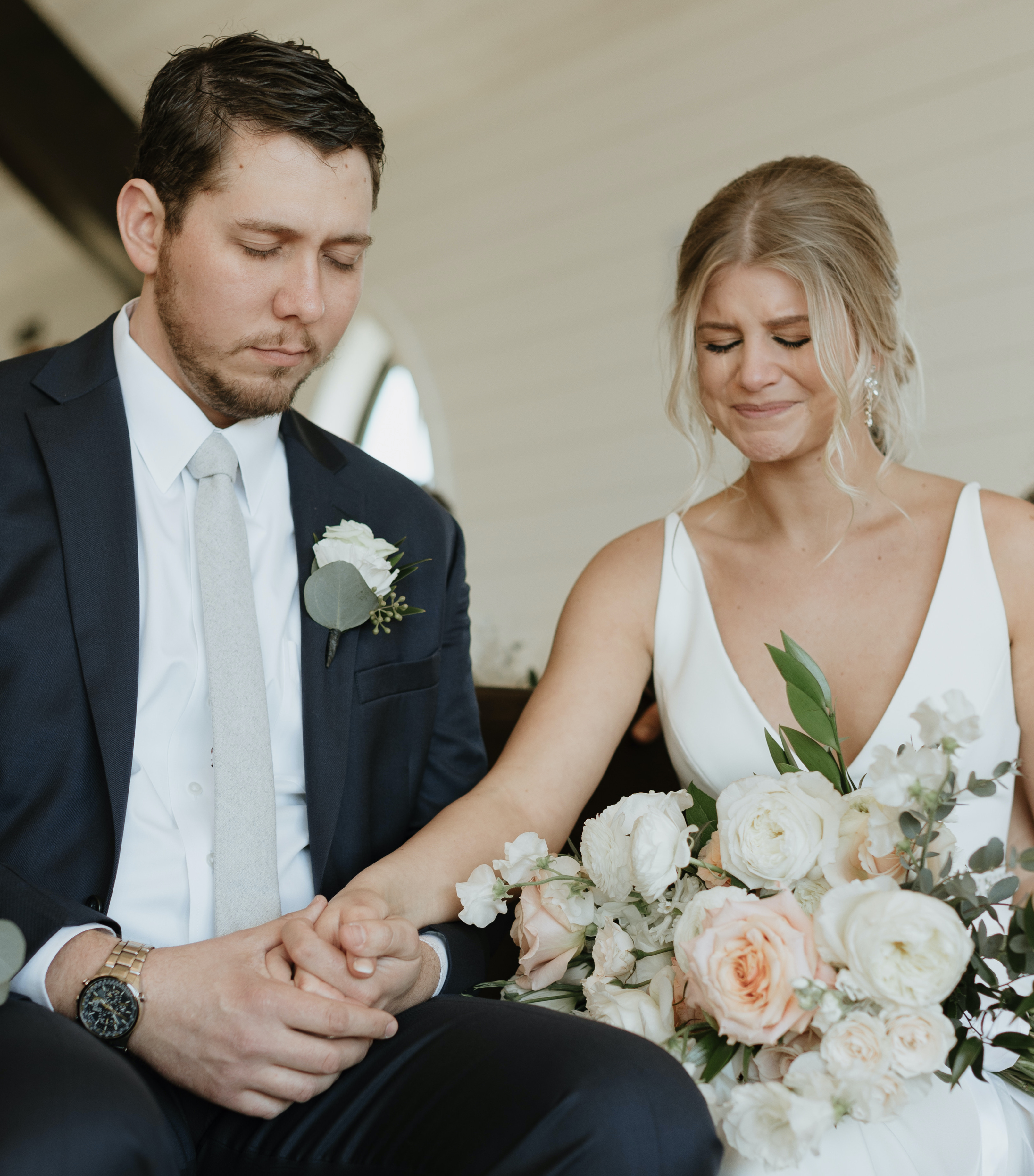 A bride and groom sit in the wedding chapel and pray before their wedding ceremony in Brenham, TX at Deep in The Heart Farms. Peach-Toned Countryside wedding.