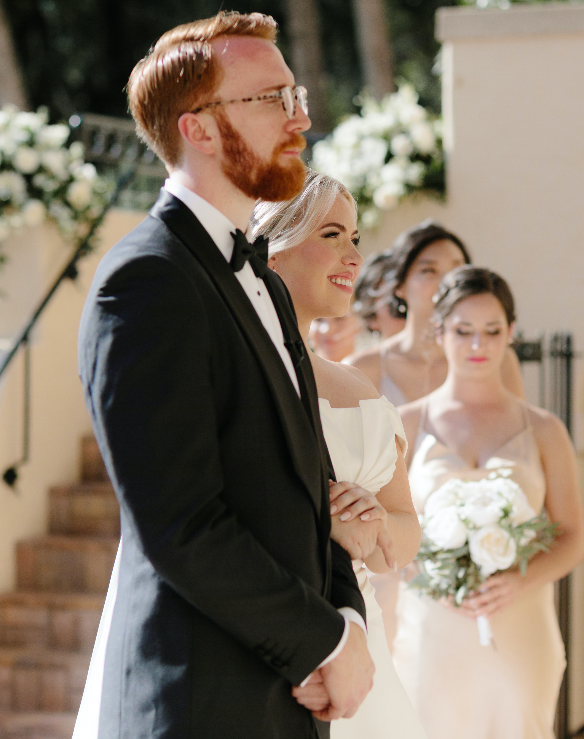 A bride and groom smile and stand at the altar during their intimate alfresco summer wedding in Sarasota, FL.