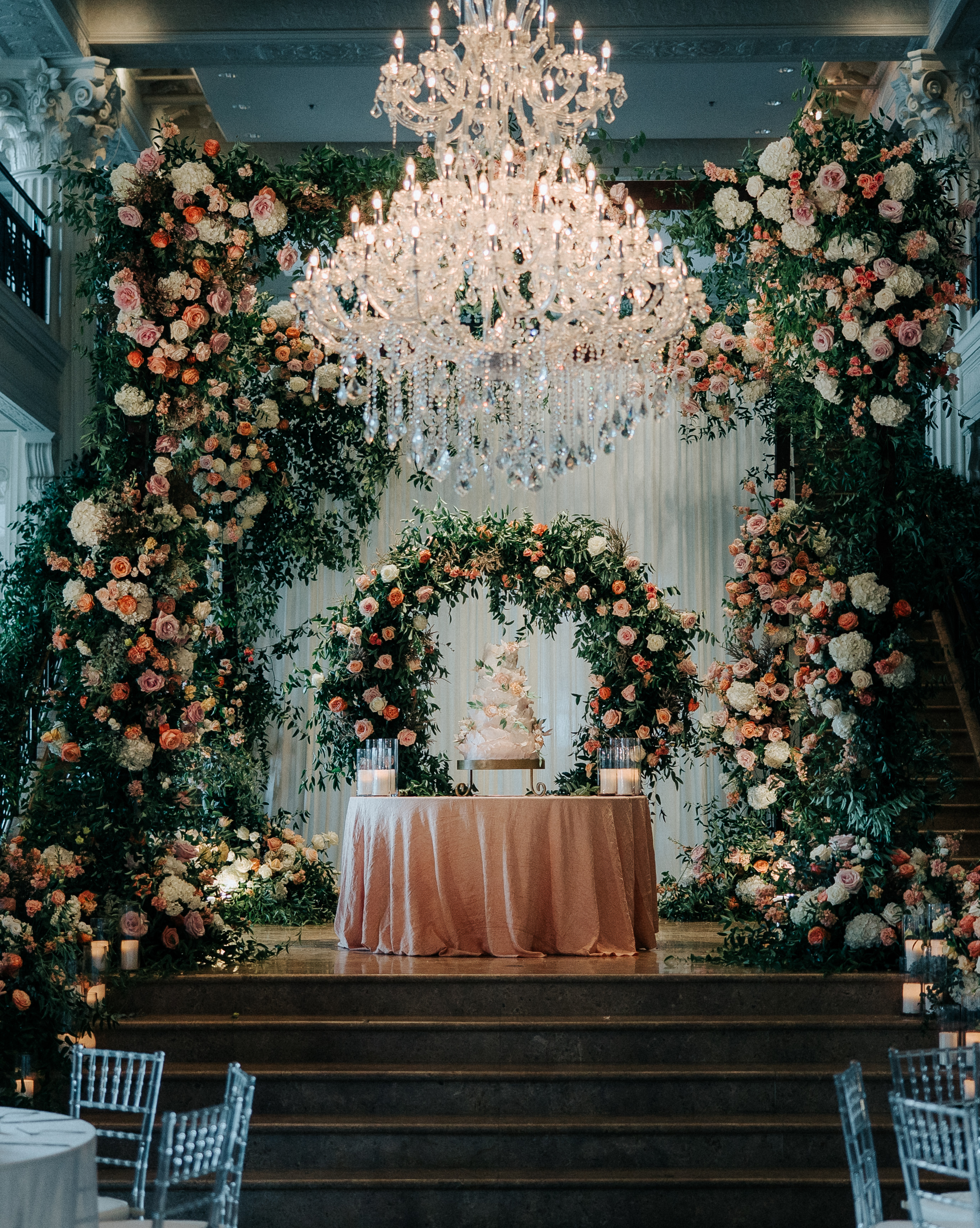 Pink, white and peach florals and greenery decorate the reception halls at the wedding venue, The Corinthian. 