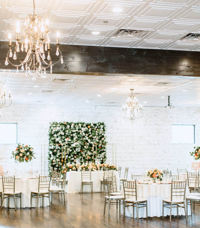 Flowers and a flower wall decorate the wedding venue, Mara Villa. 